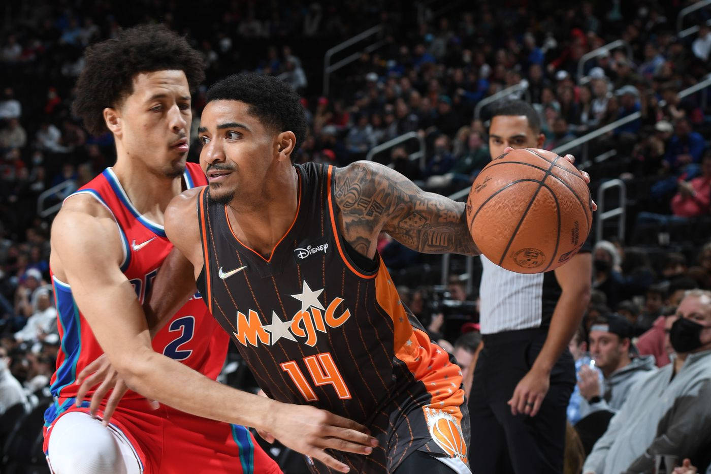 gary harris 桌布 壁紙 — 一名身穿奧蘭多魔術隊球衣的籃球運動員在擠滿觀眾的場館比賽中突破防守球員。
