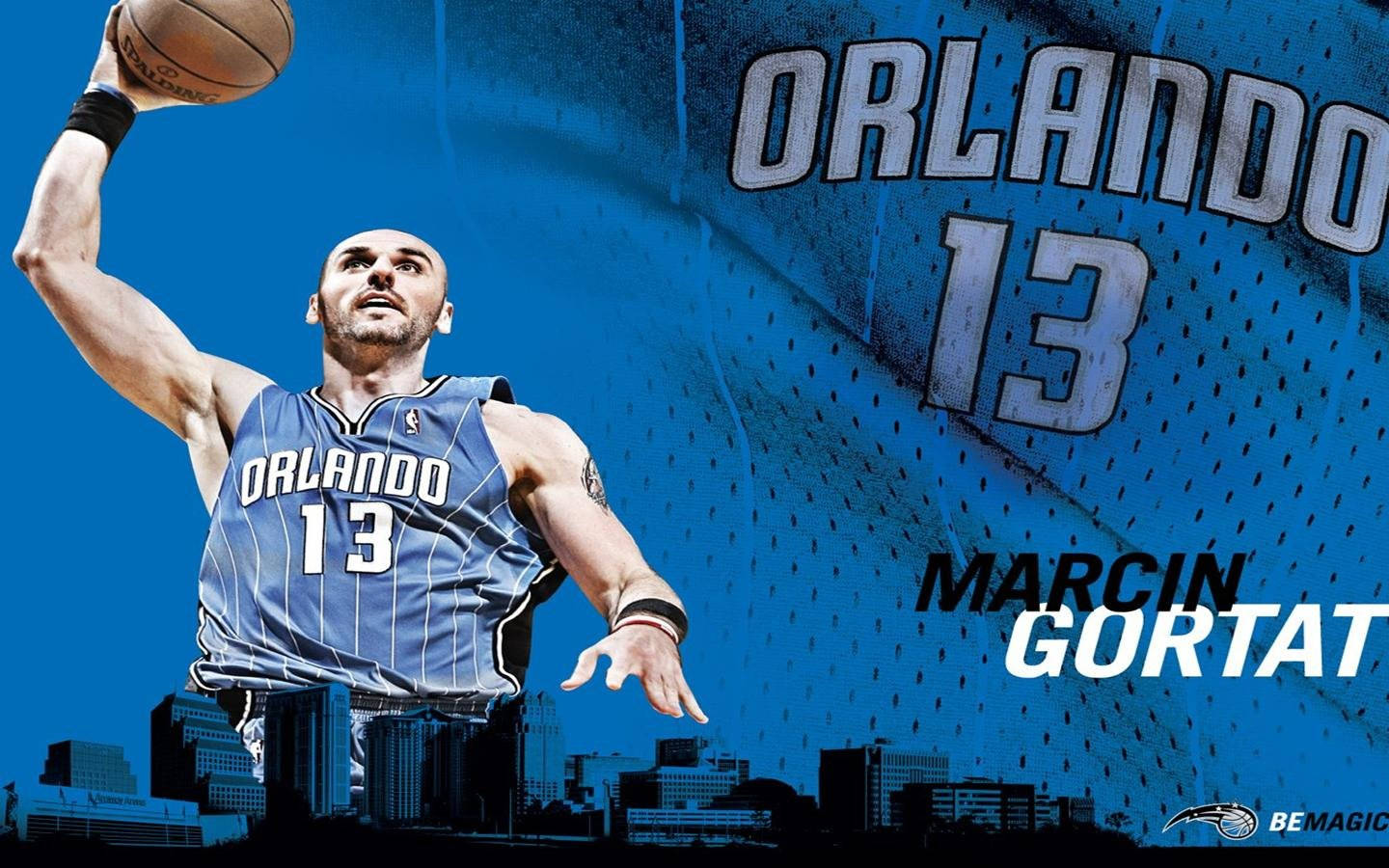 Orlando 桌布 壁紙 — 一名身穿奧蘭多魔術隊球衣的籃球運動員在藍色背景、城市天際線和球隊品牌標誌前跳起投籃。