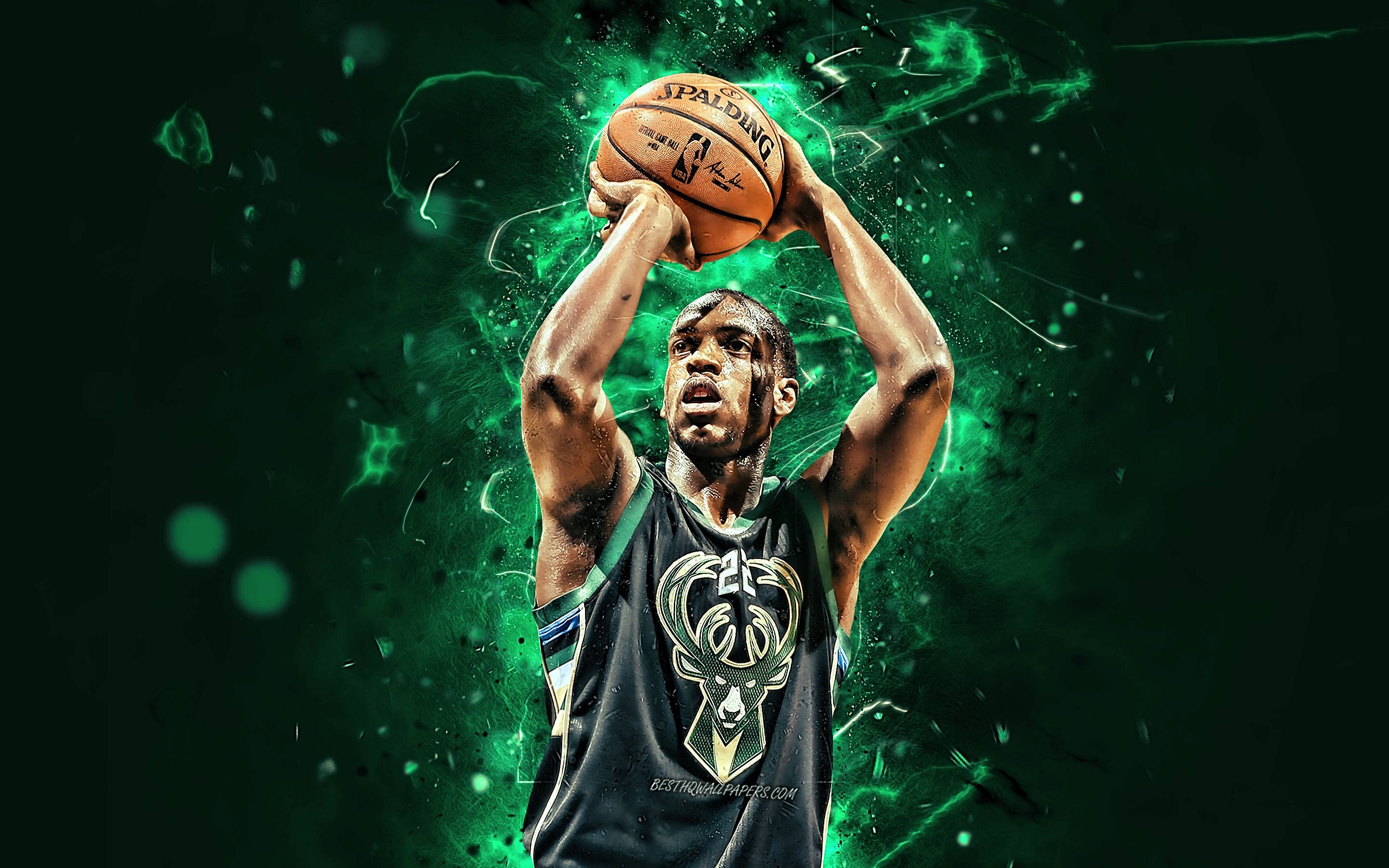 Bucks 桌布 壁紙 — 一名身穿密爾瓦基公鹿隊球衣的籃球運動員，在充滿活力的綠色能量爆發背景下投擲斯伯丁籃球。