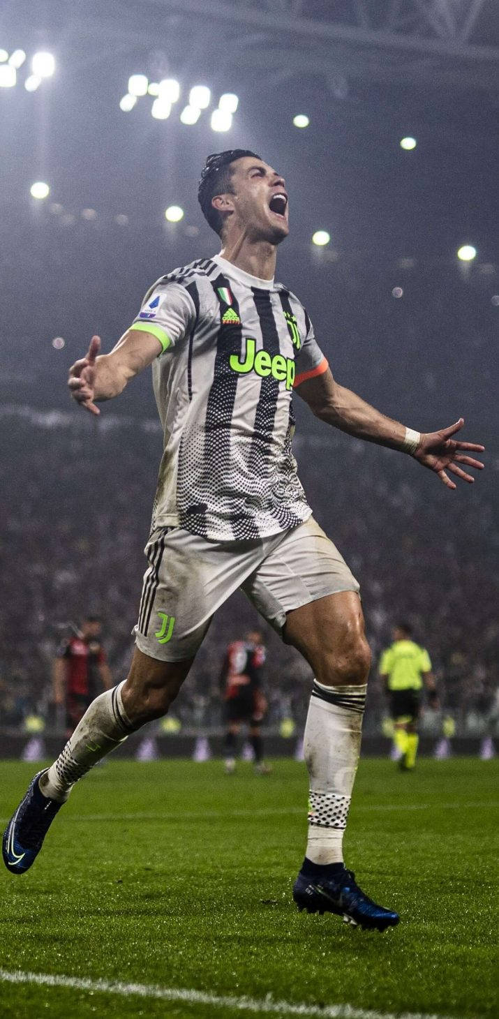 Ronaldo 桌布 壁紙 — 一名身穿尤文圖斯球衣的足球員在球場燈光下張開雙臂勝利慶祝。