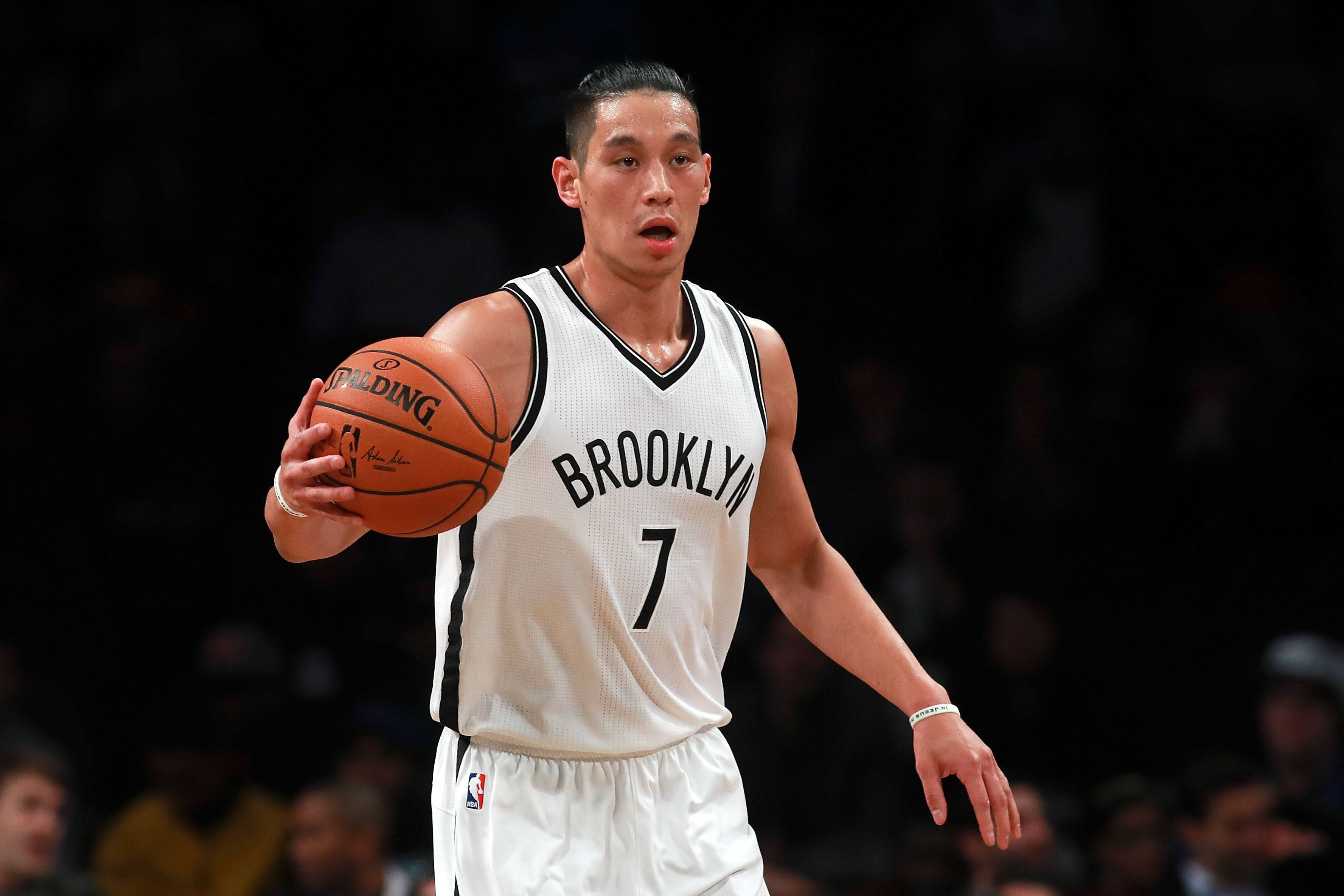Lin 桌布 壁紙 — 一名身穿布魯克林籃網球衣的籃球運動員在明亮的場館燈光下於比賽中運球。