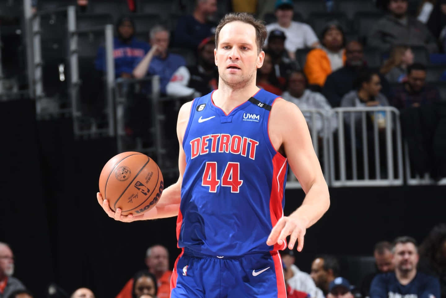 NBA 桌布 壁紙 — 一名身穿底特律活塞隊球衣的籃球運動員在明亮的場館燈光下進行激烈比賽時運球。