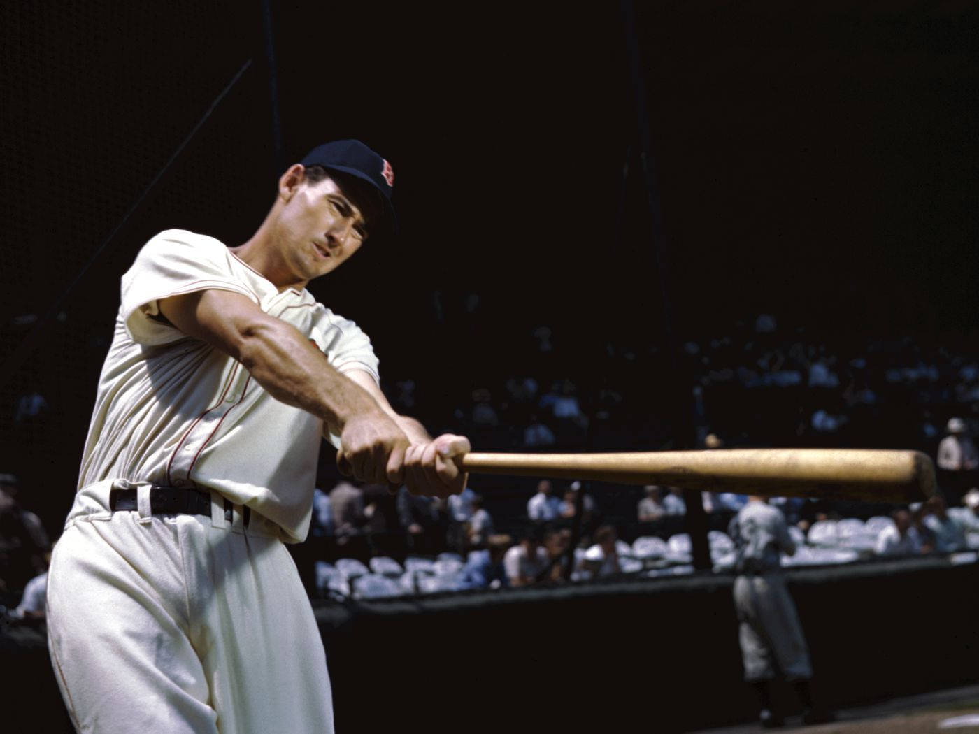 Ted Williams 桌布 壁紙 — 一名身穿復古球衣的棒球選手在球場燈光下專注地揮動木製球棒。