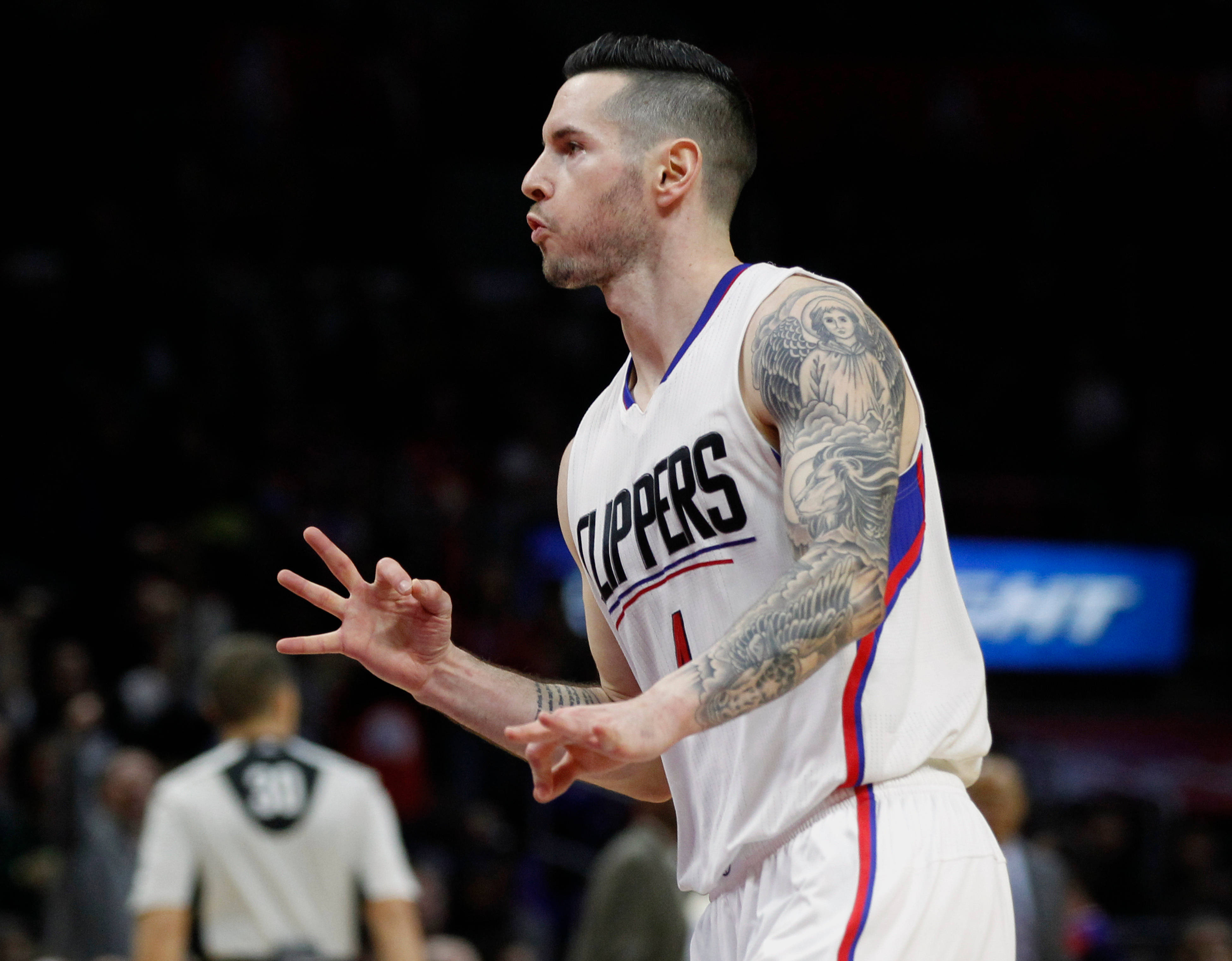 Jj Redick 桌布 壁紙 — 一名身穿快艇隊球衣的籃球運動員在明亮的場館燈光下比賽時激烈地做手勢。