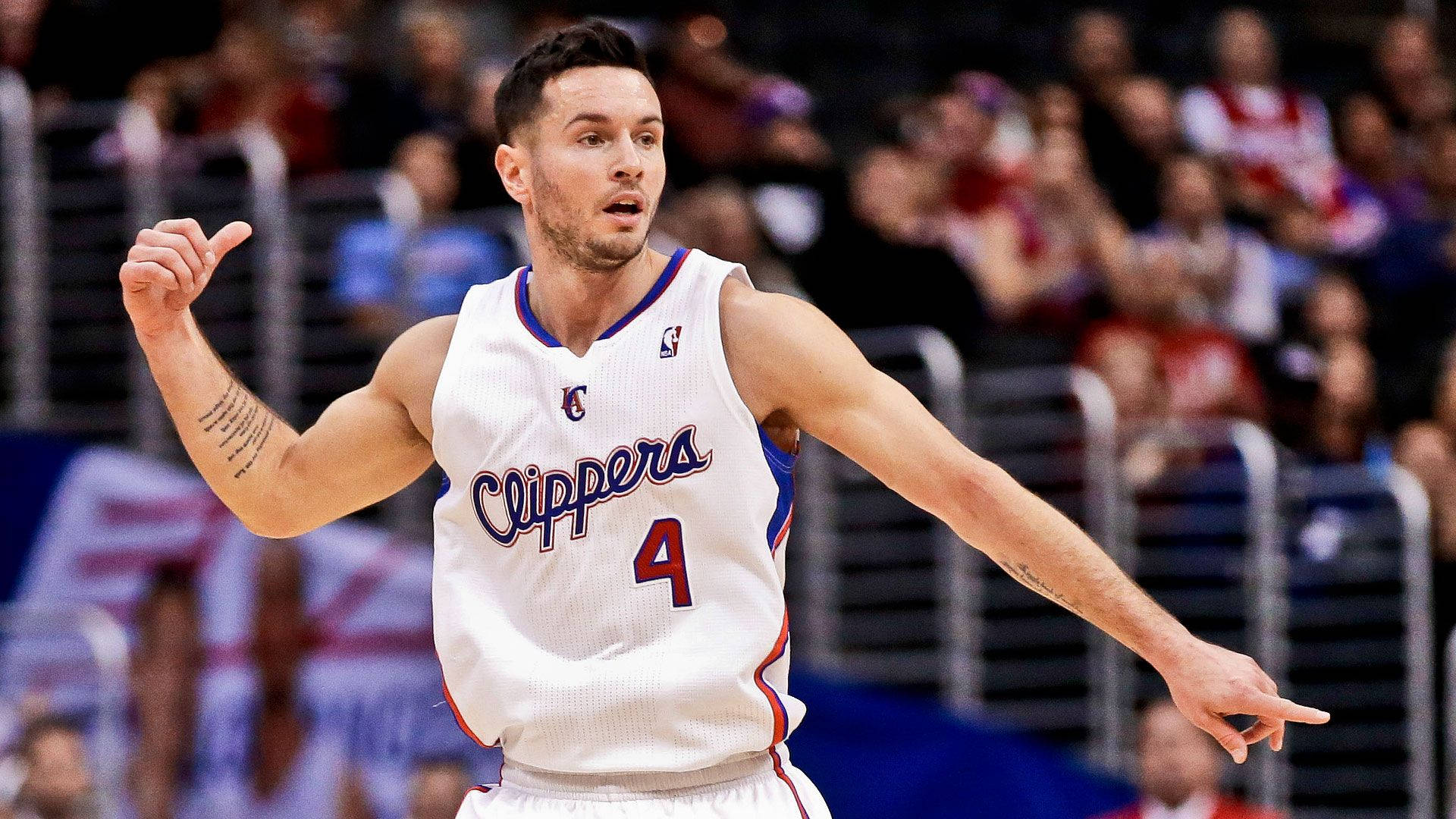 Jj Redick 桌布 壁紙 — 一名身穿快艇隊球衣的籃球運動員在比賽中激烈地做手勢，背景是模糊的人群。