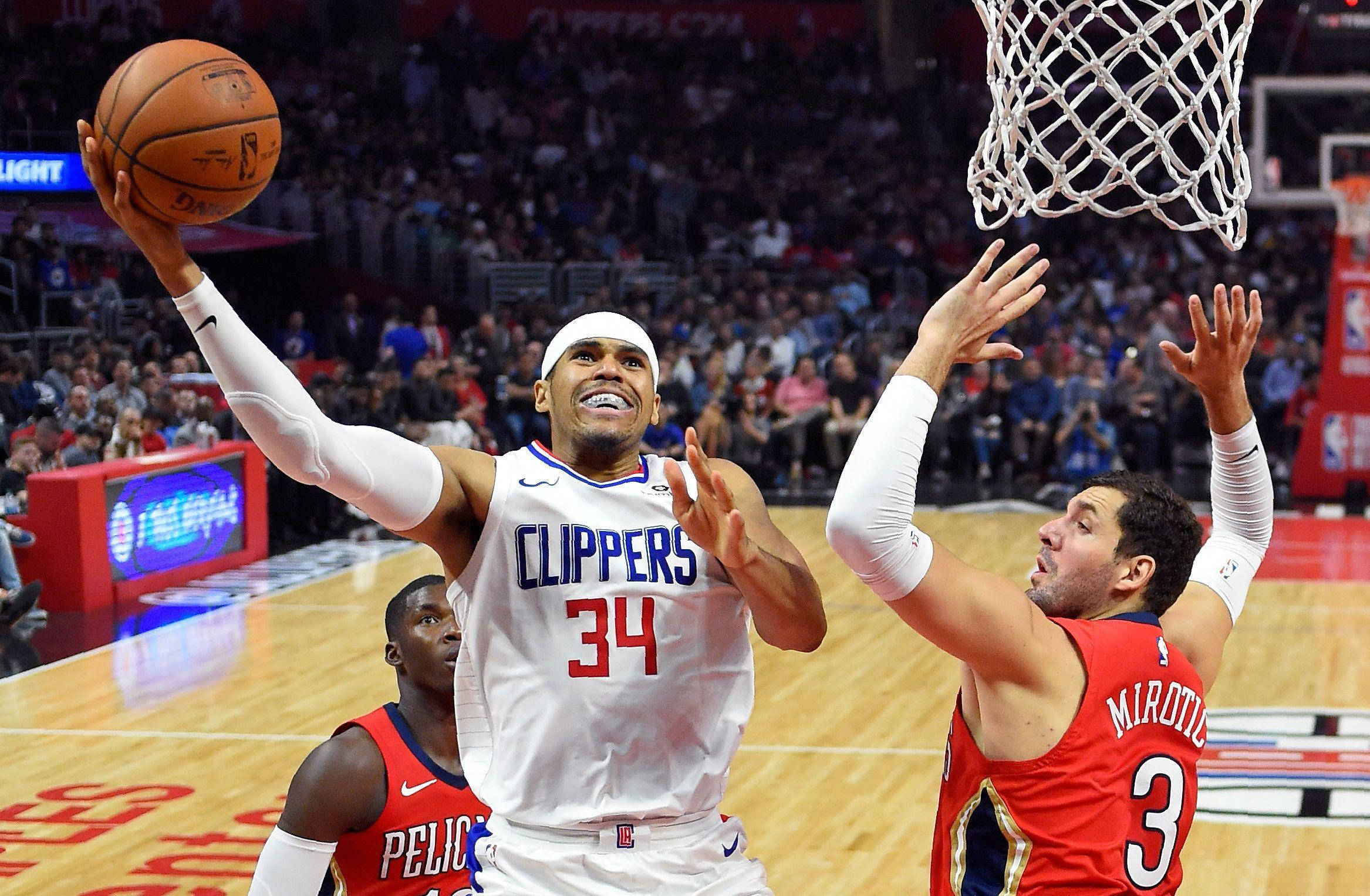 NBA 桌布 壁紙 — 一名身穿快艇隊球衣的籃球運動員跳向籃框，同時被一名身穿鵜鶘隊球衣的對手防守。