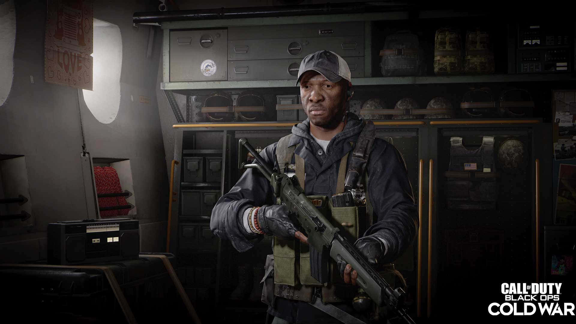 Call Of Duty Black Ops Cold War 桌布 壁紙 — 一名身穿戰術裝備的士兵在光線昏暗、裝滿設備的軍事儲藏室內手持步槍。