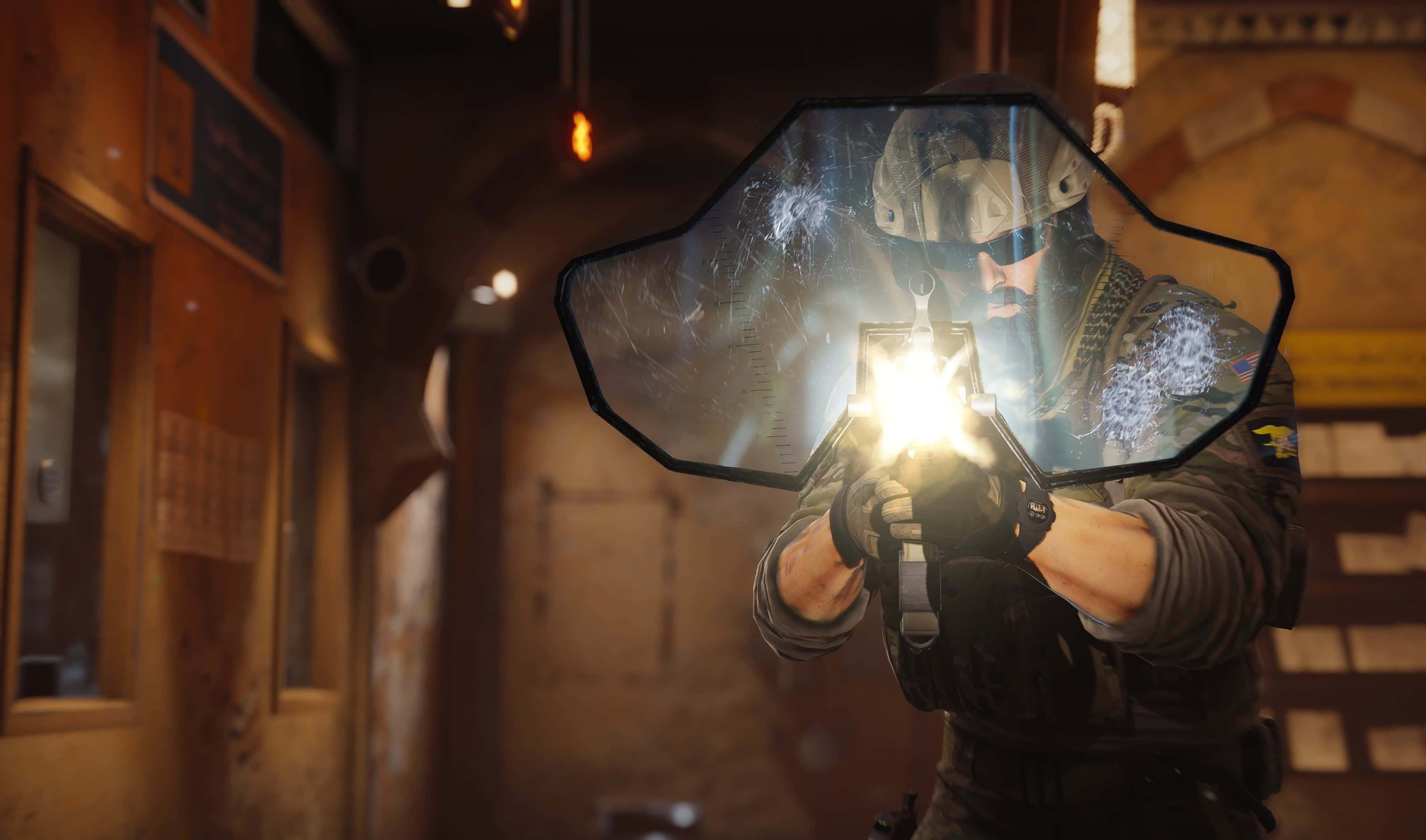 Rainbow Six Siege Blackbeard 桌布 壁紙 — 一名身穿戰術裝備的士兵在光線昏暗的城市走廊中，透過破裂的六角形盾牌發射發光武器。