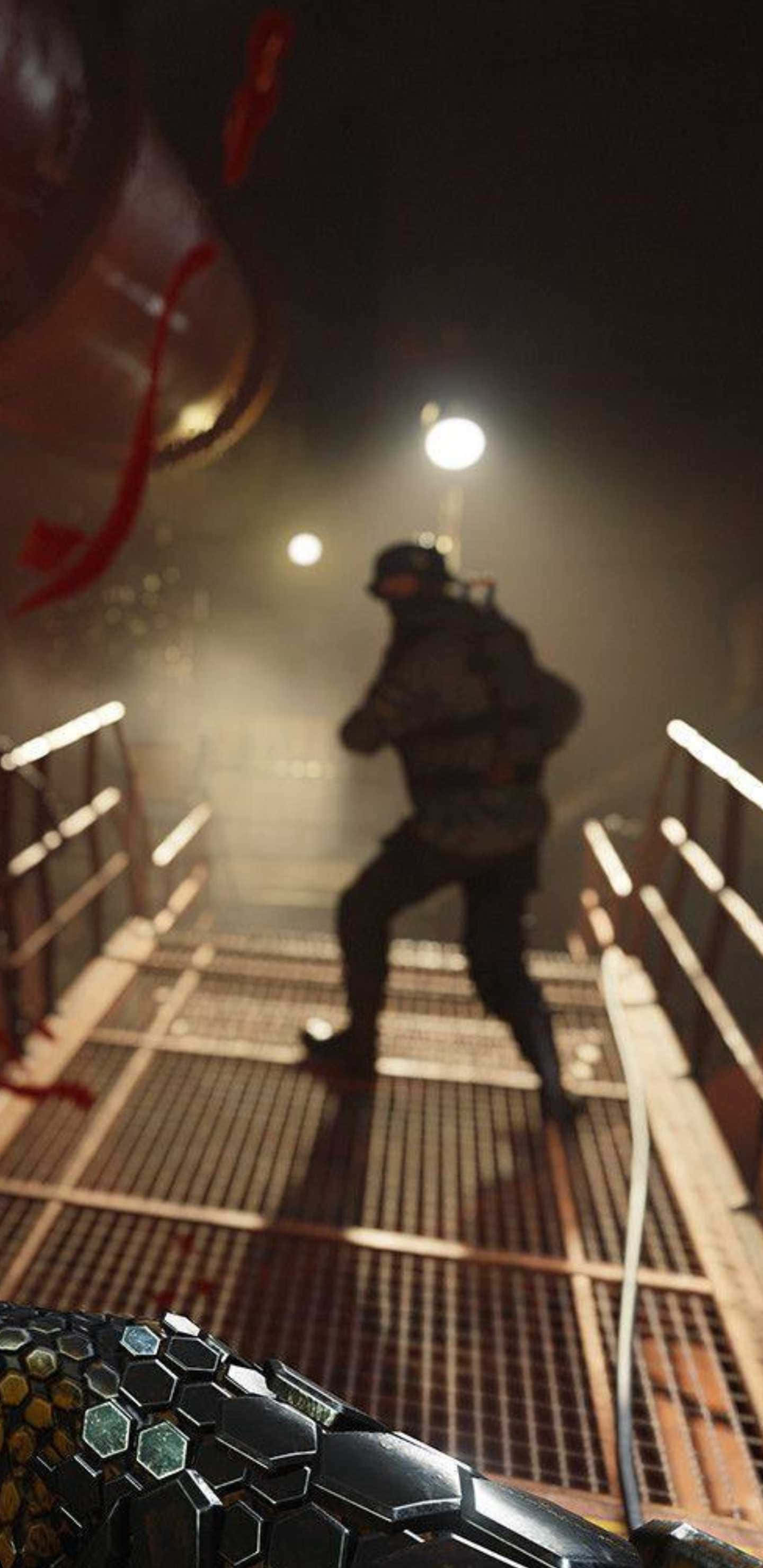 video games 桌布 壁紙 — 一名身穿戰術裝備的士兵在煙霧瀰漫、燈光昏暗的工業設施中跑下金屬樓梯，前景有一把發光的武器。