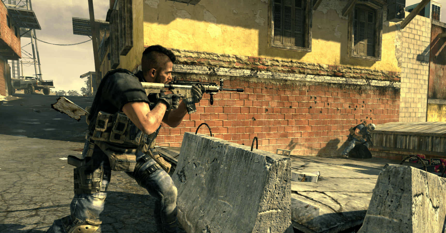 Soap Mactavish 桌布 壁紙 — 一名身穿戰術裝備的士兵在陽光照耀、飽受戰爭摧殘的城市小巷中，從混凝土路障後方瞄準步槍。