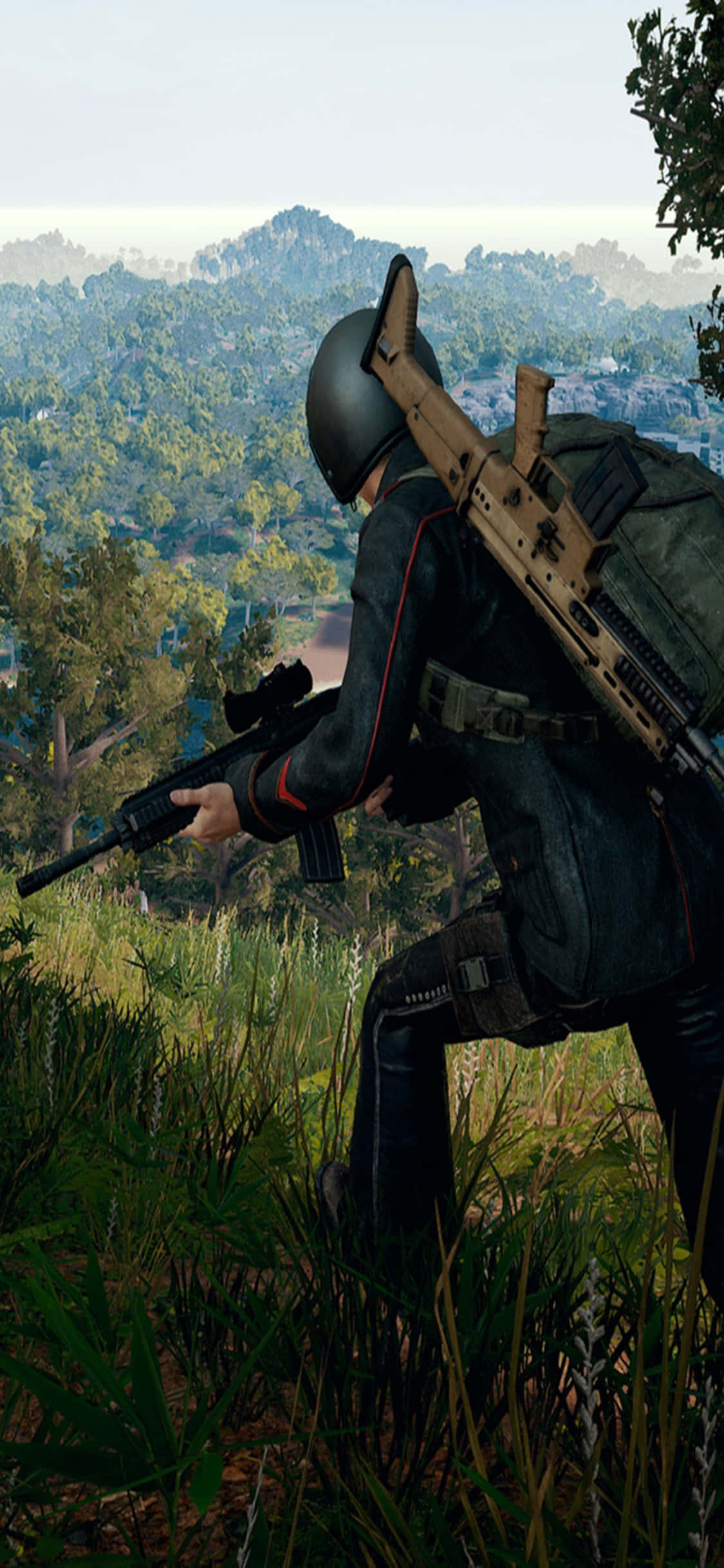 Playerunknown's Battlegrounds 桌布 壁紙 — 一名身穿戰術裝備的士兵蹲在高草叢中，用步槍瞄準一個有遠山樹林覆蓋的山谷。