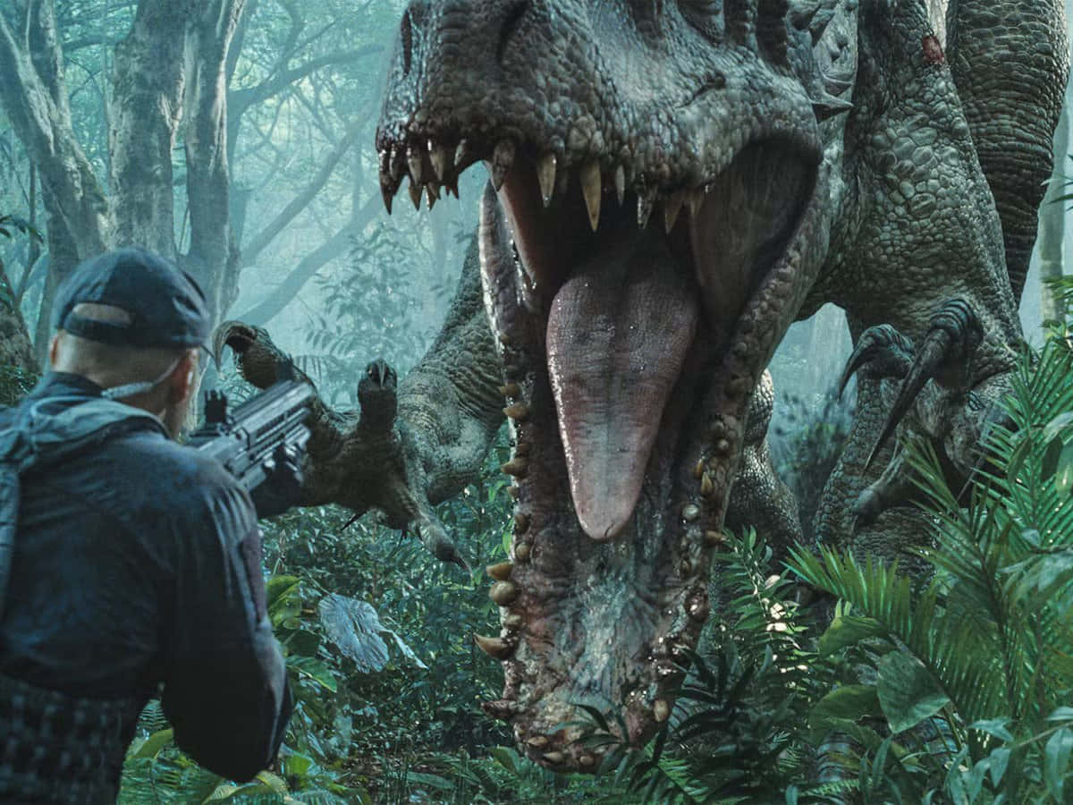 Jurassic World 桌布 壁紙 — 一名身穿戰術裝備的男子在霧氣瀰漫的叢林中，用步槍瞄準一隻巨大的咆哮暴龍。