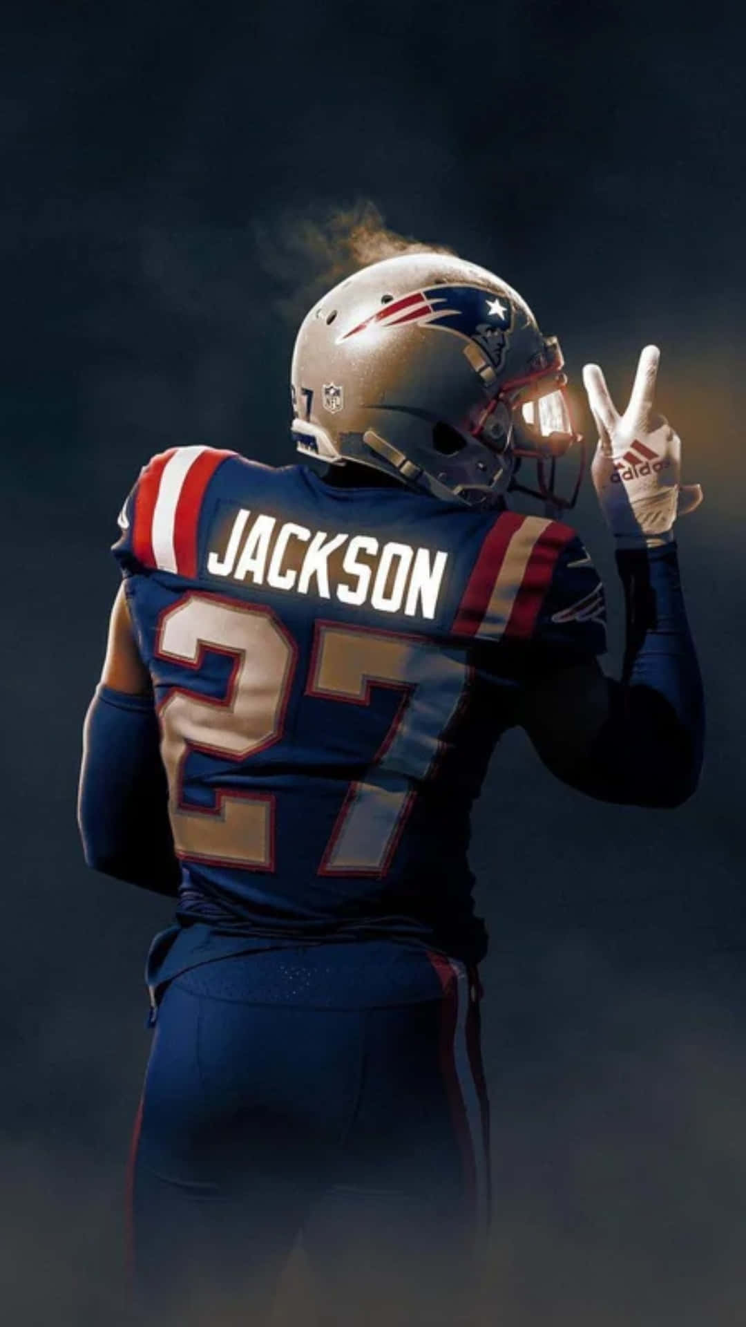 足球 桌布 壁紙 — 一名身穿新英格蘭愛國者隊球衣、名字為Jackson、號碼27的美式足球運動員，在煙霧瀰漫的黑暗環境中背對鏡頭做出和平手勢。
