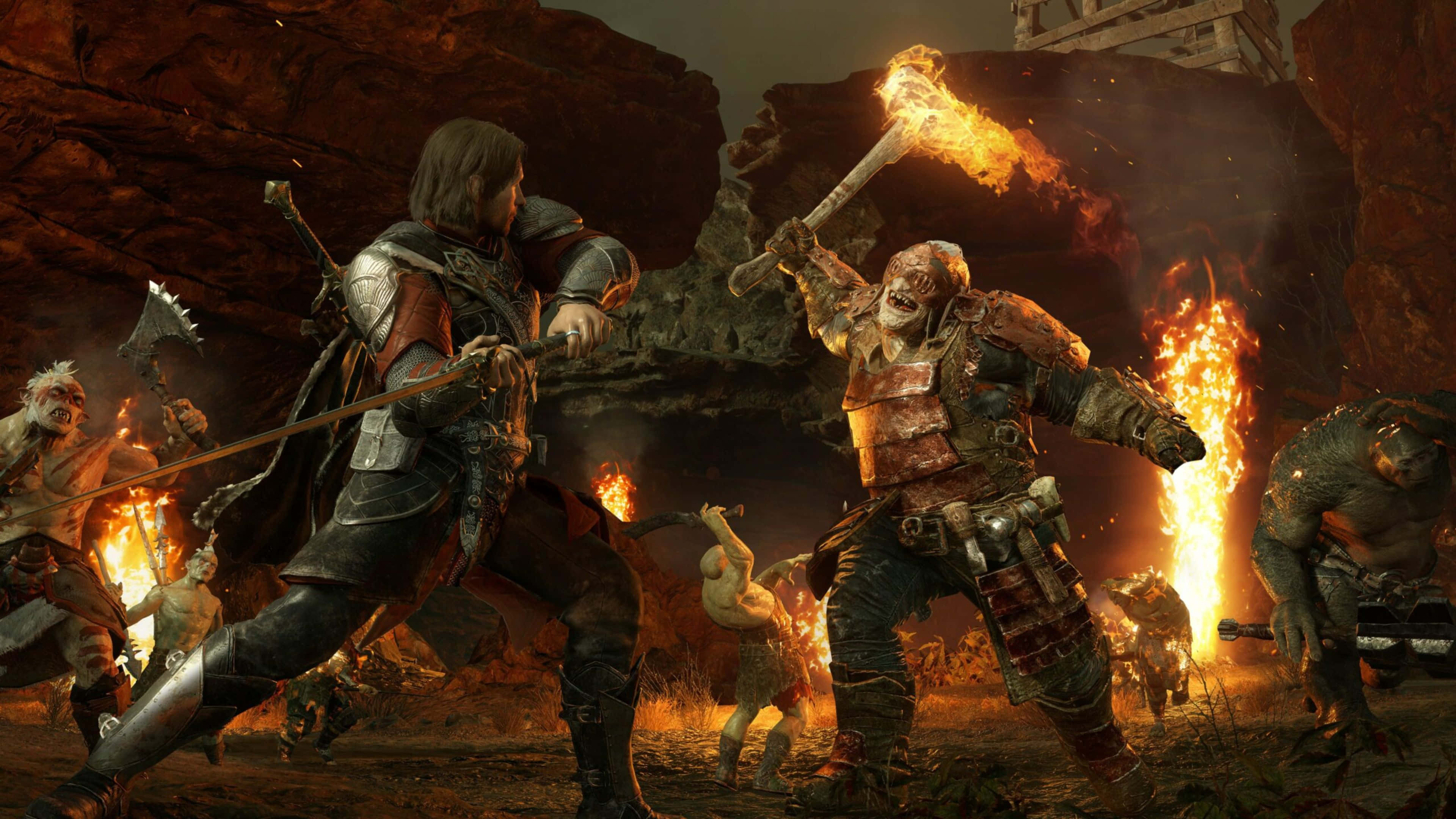 4K Shadow Of War 桌布 壁紙 — 一名身穿暗色盔甲的戰士與一名揮舞著火焰火炬的獸人在熾熱的岩石戰場上交鋒。