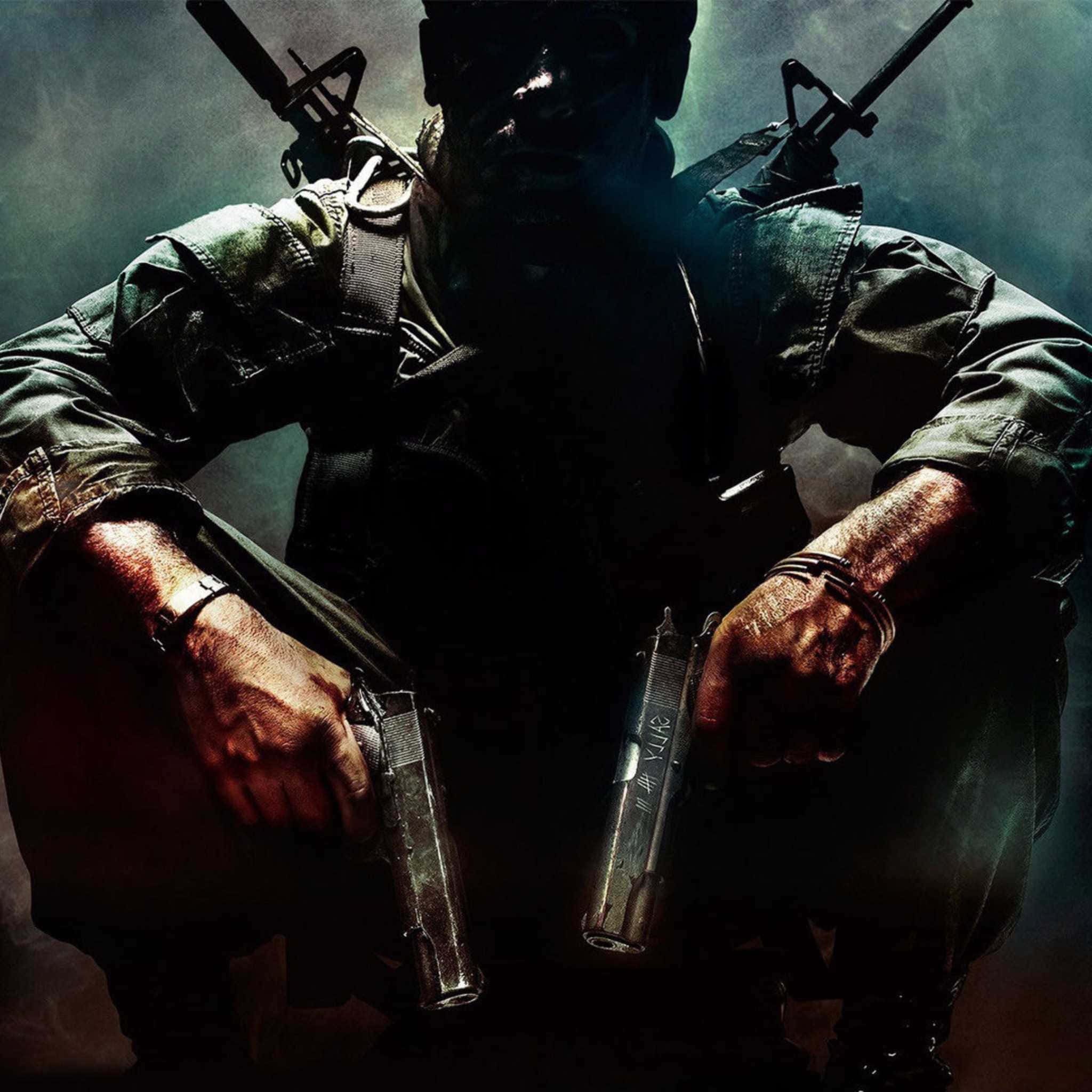 Call Of Duty Weapons 桌布 壁紙 — 一名身穿暗色裝備的粗獷士兵蹲下，手持兩把手槍，肩上掛著步槍，身處煙霧瀰漫、燈光昏暗的場景。