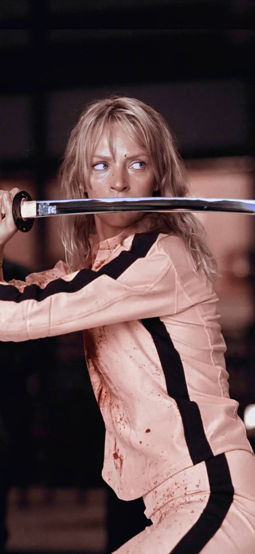 Kill Bill 桌布 壁紙 — 一名身穿染血粉紅與黑色服裝的女性，以緊張的戰鬥姿態握著一把武士刀。