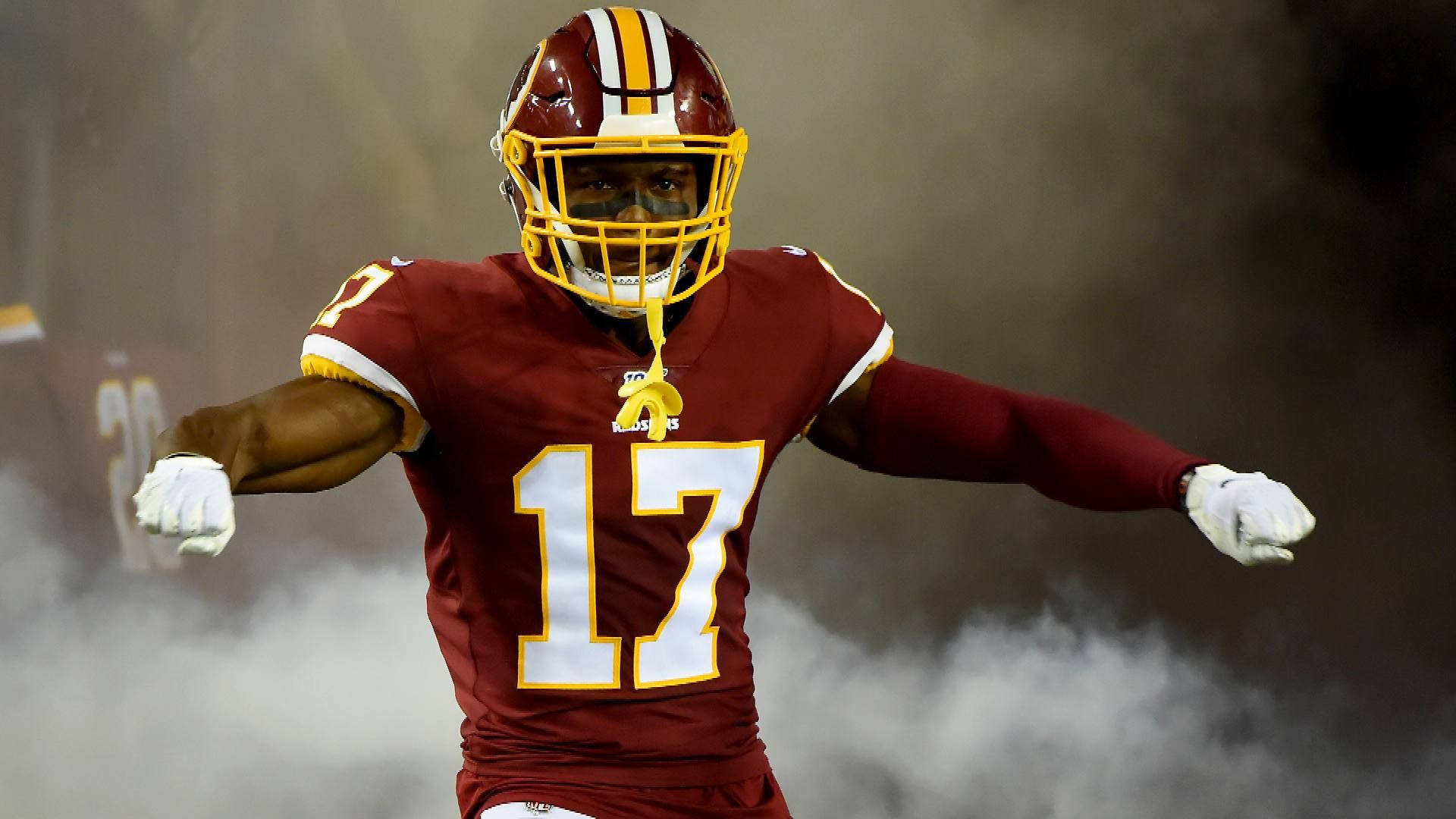 Football Players 桌布 壁紙 — 一名身穿栗色球衣、號碼17的足球員在夜間的場地上穿過煙霧奔跑。