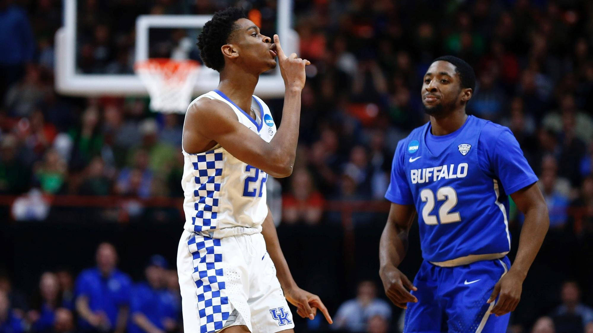 Shai Gilgeous Alexander 桌布 壁紙 — 一名身穿格子球衣的籃球運動員準備投籃，而一名水牛隊球員在比賽中專注地觀看。