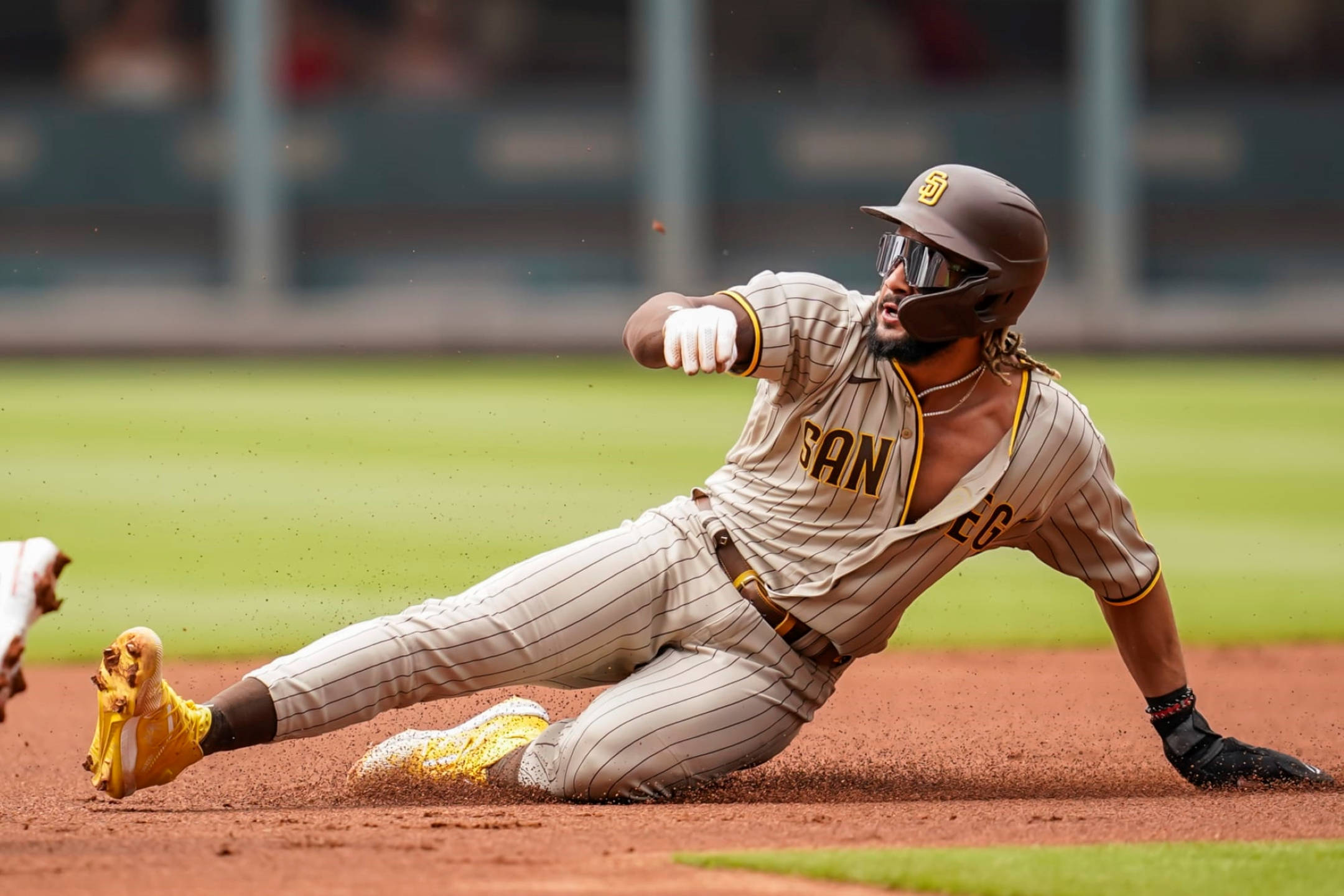 Padres 桌布 壁紙 — 一名身穿條紋球衣的棒球運動員在日間比賽中頭部滑壘進壘，揚起泥土。