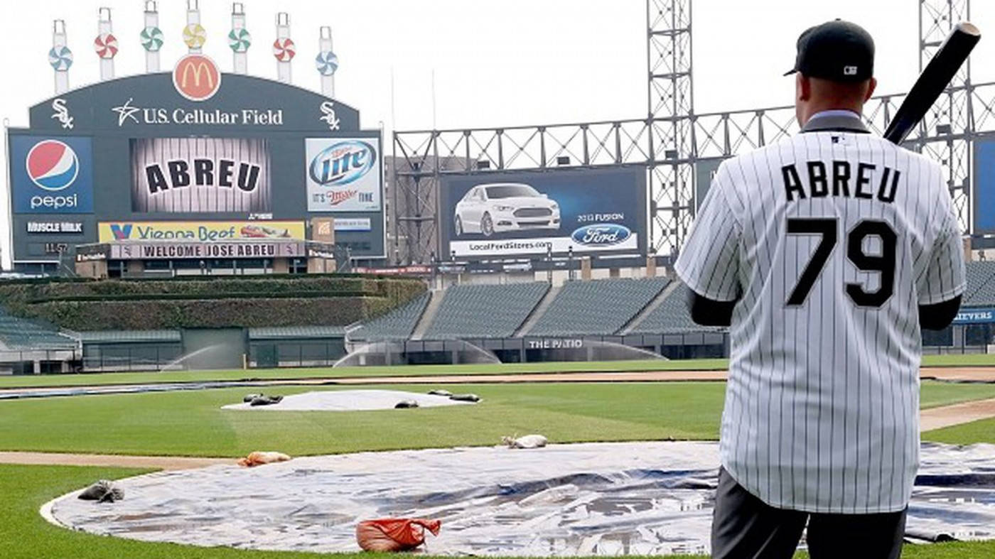jose abreu 桌布 壁紙 — 一名身穿條紋球衣的棒球運動員站在U.S. Cellular Field的有蓋場地上，身後是球場廣告和空座位。