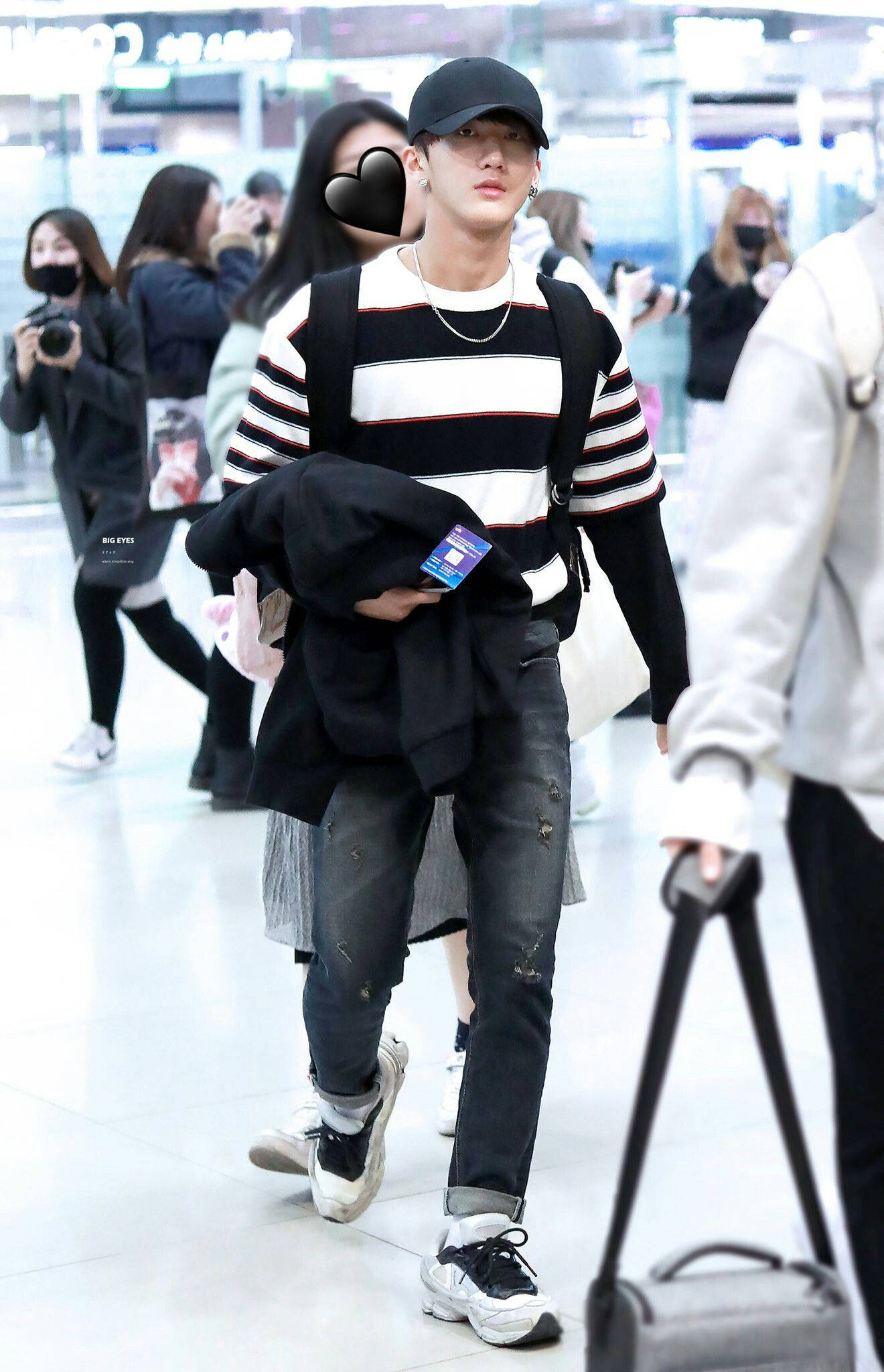 Changbin 桌布 壁紙 — 一名身穿條紋襯衫和帽子的年輕男子，拿著外套和登機證，穿過繁忙的機場航廈。