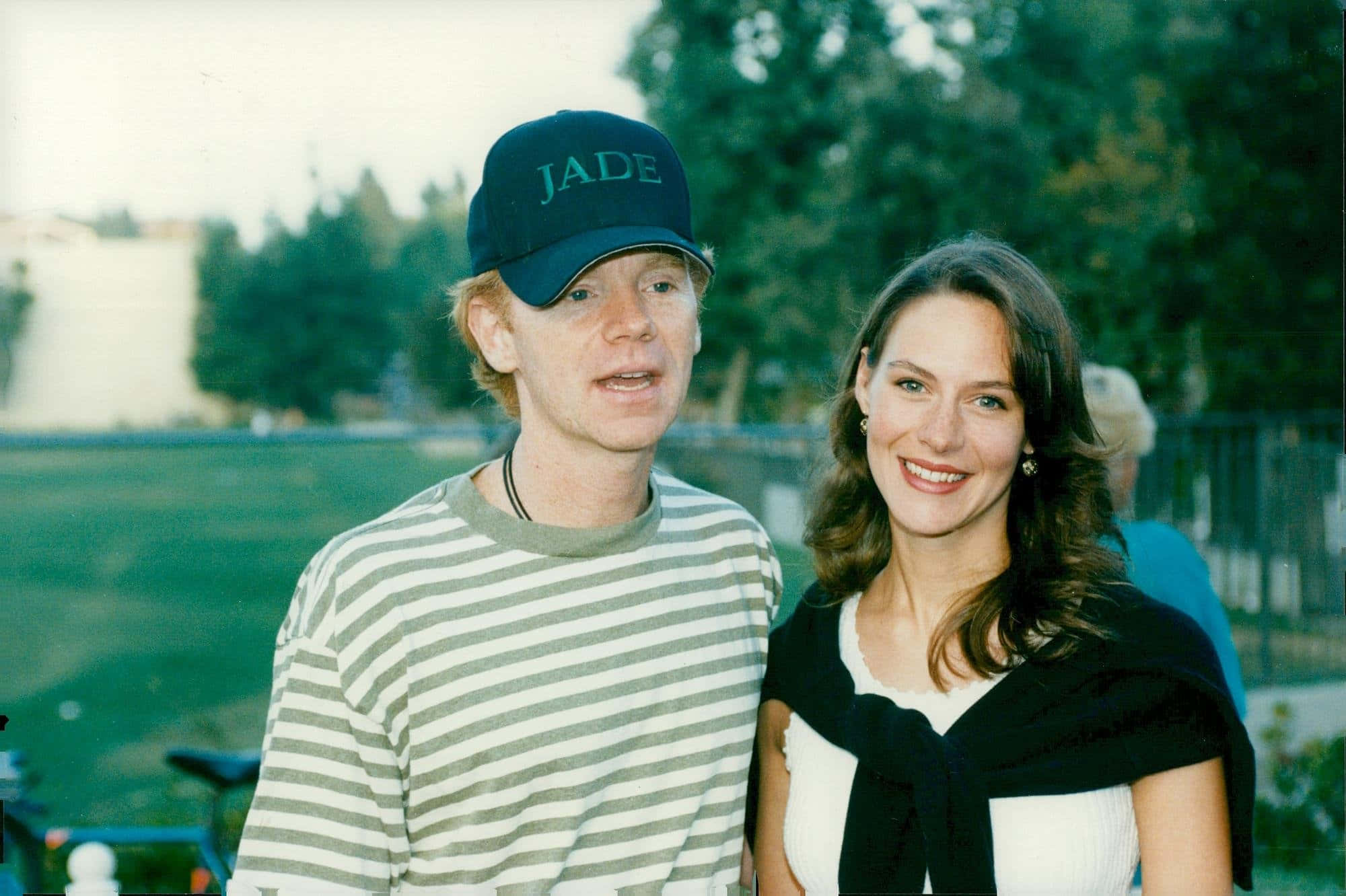 David Caruso 桌布 壁紙 — 一名身穿條紋襯衫和帽子的男士，站在一位微笑、披著黑色披肩的女士旁邊，在戶外。