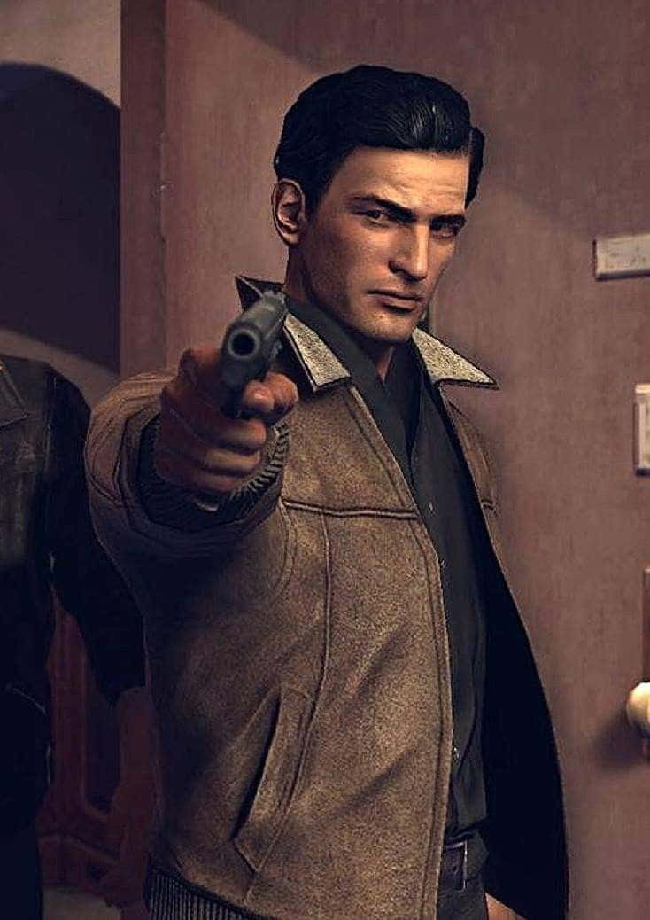Mafia 桌布 壁紙 — 一名身穿棕色外套的男子在昏暗的室內環境中，直接將手槍瞄準觀眾。