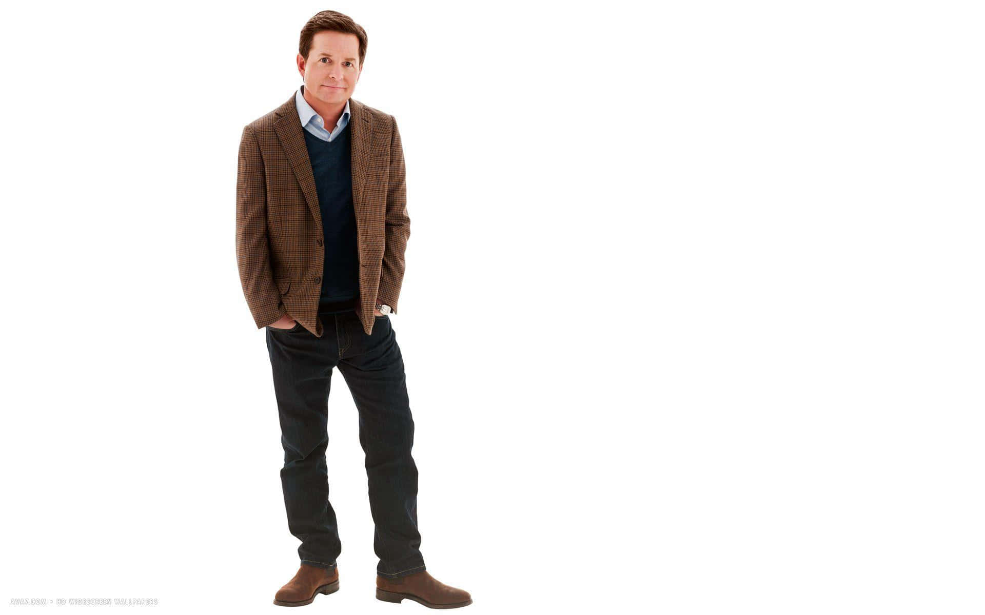 michael j fox 桌布 壁紙 — 一名身穿棕色格紋西裝外套和深色牛仔褲的男子，雙手插袋，自信地站在純白色背景前。