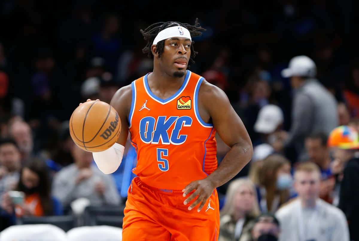 NBA 桌布 壁紙 — 一名身穿橙色OKC球衣的籃球運動員在比賽中運球，背景是模糊的觀眾。