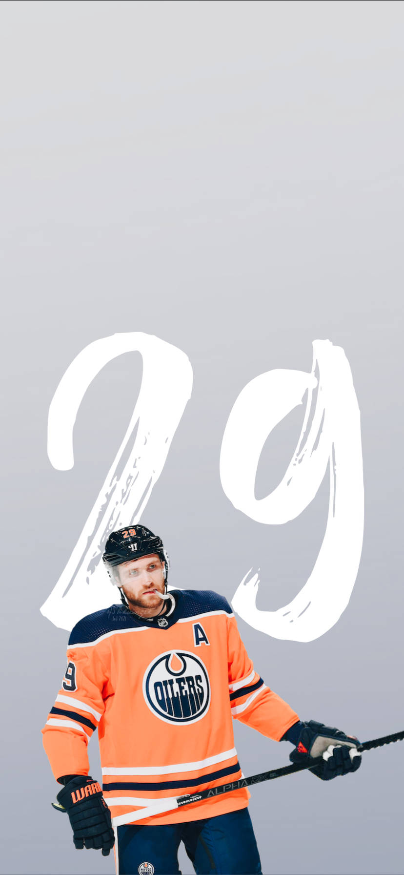 hockey 桌布 壁紙 — 一名身穿橙色愛德蒙頓油人隊球衣的曲棍球運動員自信地站著，手持球棍，身後灰色背景上有一個大型白色「29」圖案。
