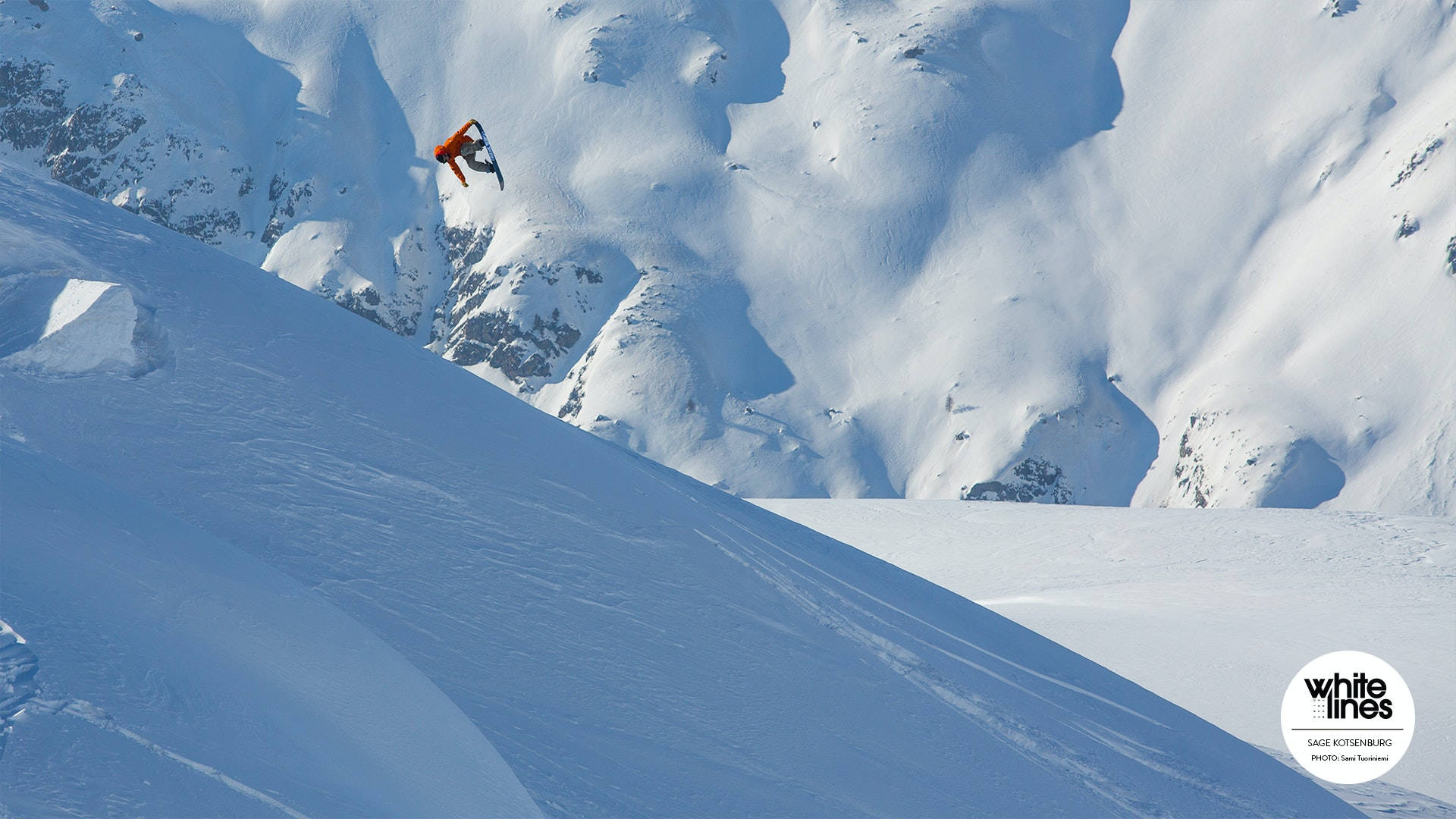 Snowboarding 桌布 壁紙 — 一名身穿橙色滑雪板運動員在明亮的日光下，在陡峭的積雪山坡上空翱翔。