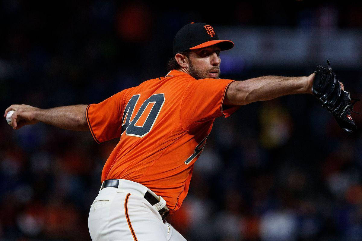 madison bumgarner 桌布 壁紙 — 一名身穿橙色球衣、背號40的棒球投手在夜間比賽中，於球場燈光下準備投球。