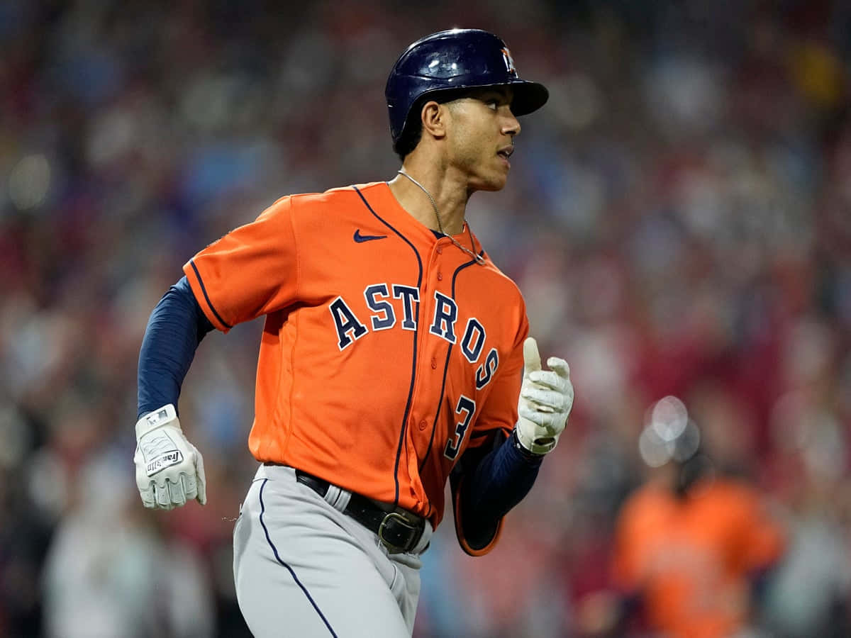 Astros 桌布 壁紙 — 一名身穿橙色球衣的休士頓太空人棒球選手在球場燈光下的夜間比賽中專注地衝刺。