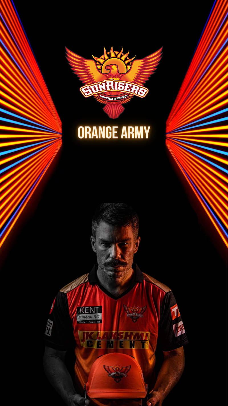 Sunrisers Hyderabad 桌布 壁紙 — 一名身穿橙色球衣的板球運動員在發光的紅藍光束下手持頭盔，上方有Sunrisers Hyderabad標誌。