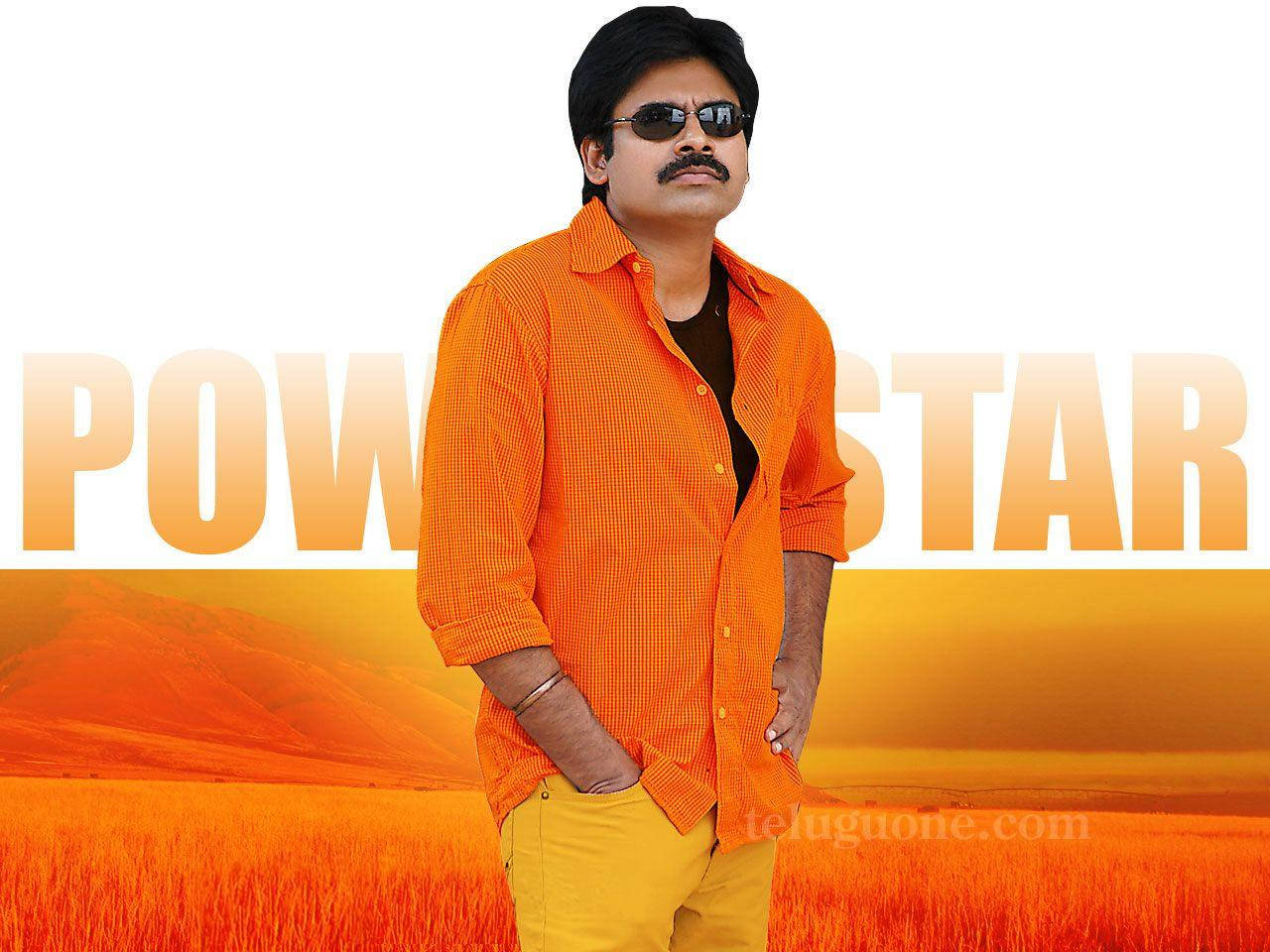 Pawan Kalyan 桌布 壁紙 — 一名身穿橙色襯衫和黃色褲子的男子自信地站在金色田野中，身後有「POWER STAR」文字。