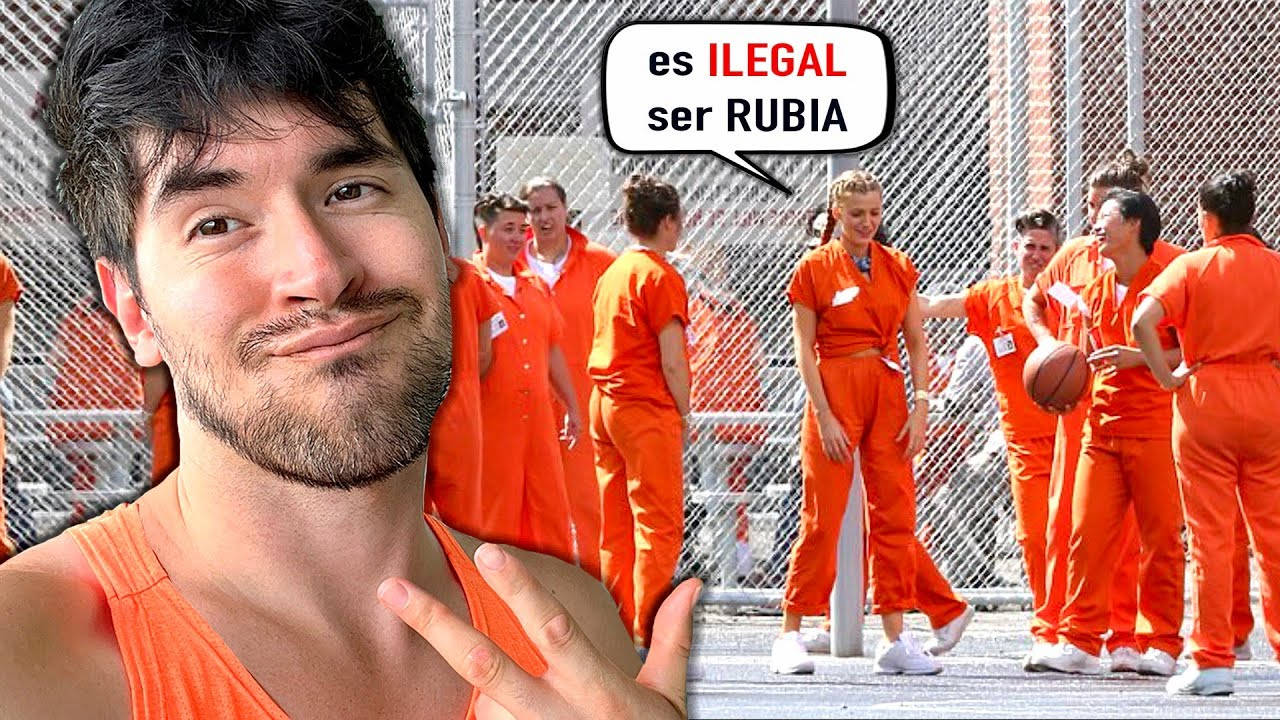 Prison 桌布 壁紙 — 一名身穿橙色連身衣的男子對著鏡頭微笑，而穿著相同制服的囚犯在鐵絲網圍欄後面打籃球。
