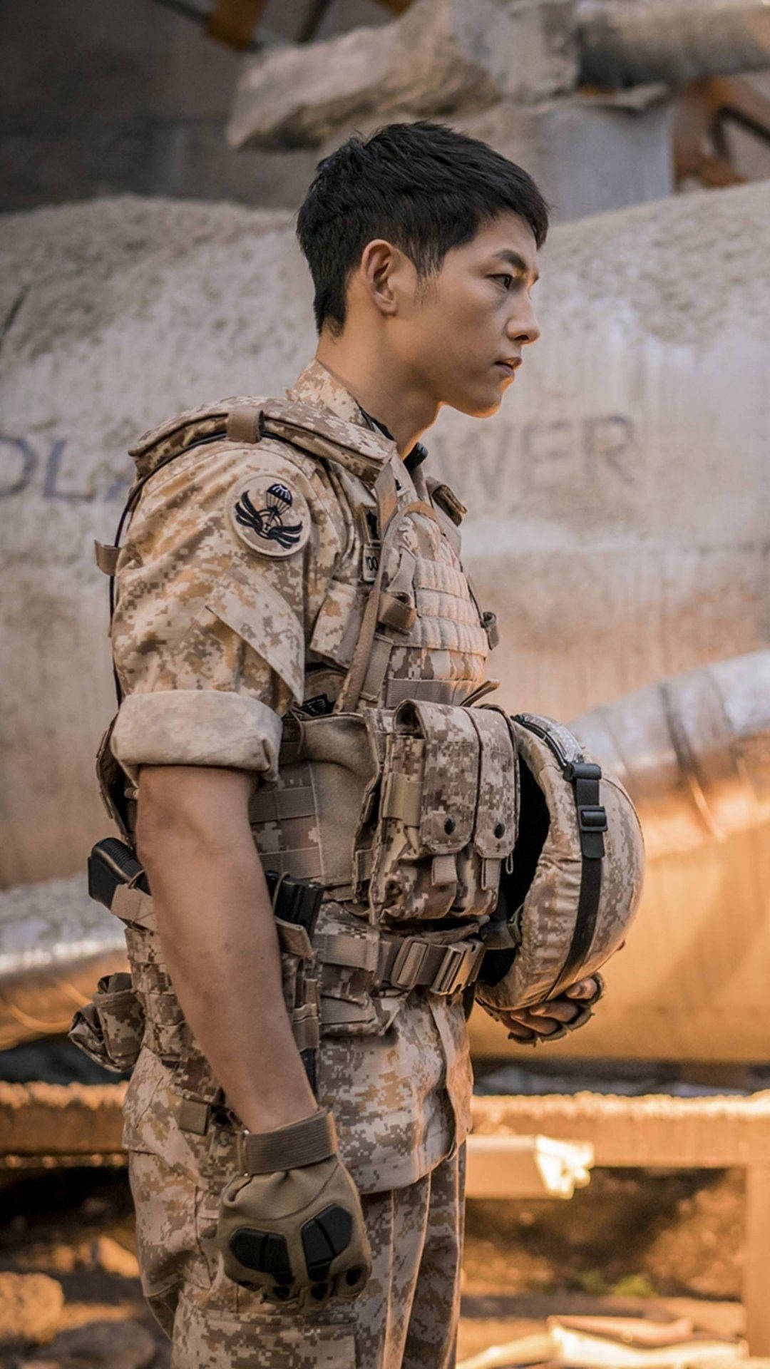 drama 桌布 壁紙 — 一名身穿沙漠迷彩服的士兵在戰火摧殘的城市廢墟中警覺地站在生鏽的坦克旁。