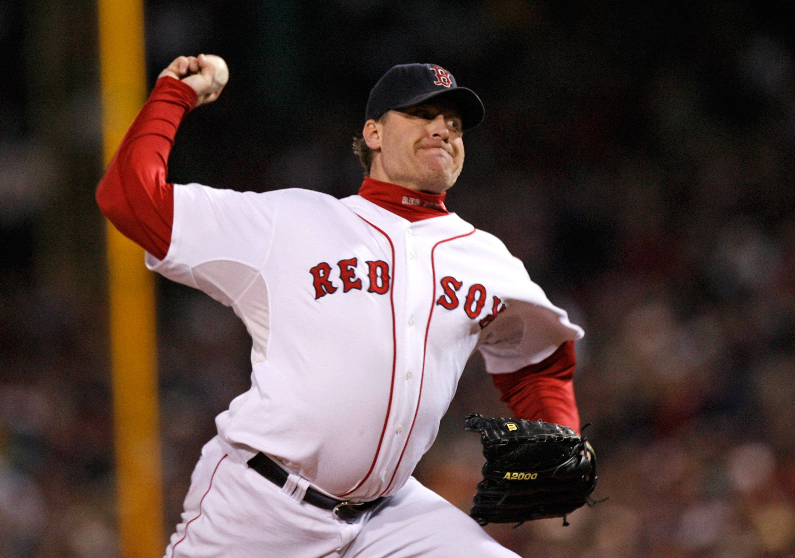 Boston Red Sox 桌布 壁紙 — 一名身穿波士頓紅襪隊球衣的棒球投手在球場燈光下，以高度專注力投出強力一球。