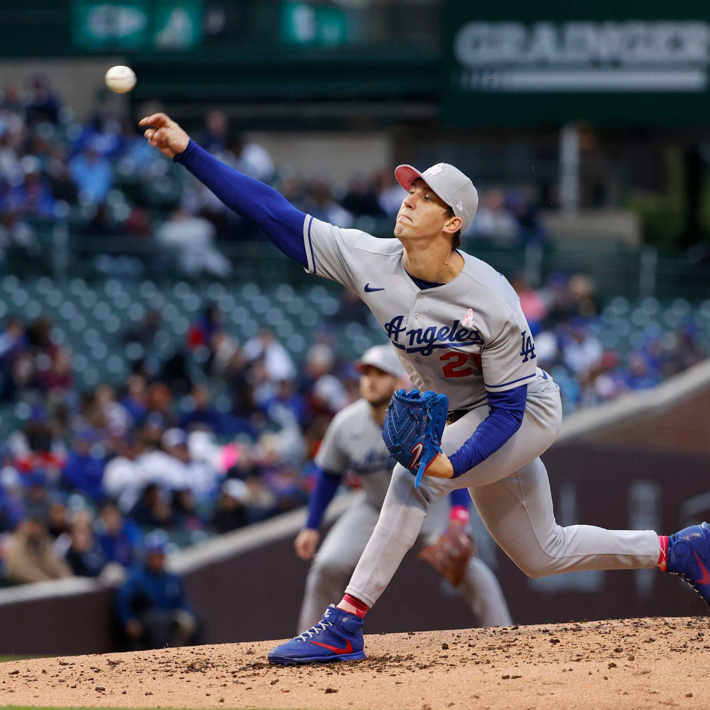 walker buehler 桌布 壁紙 — 一名身穿洛杉磯道奇隊球衣的棒球投手在陽光普照的投手丘上投球，身後是模糊的體育場人群。