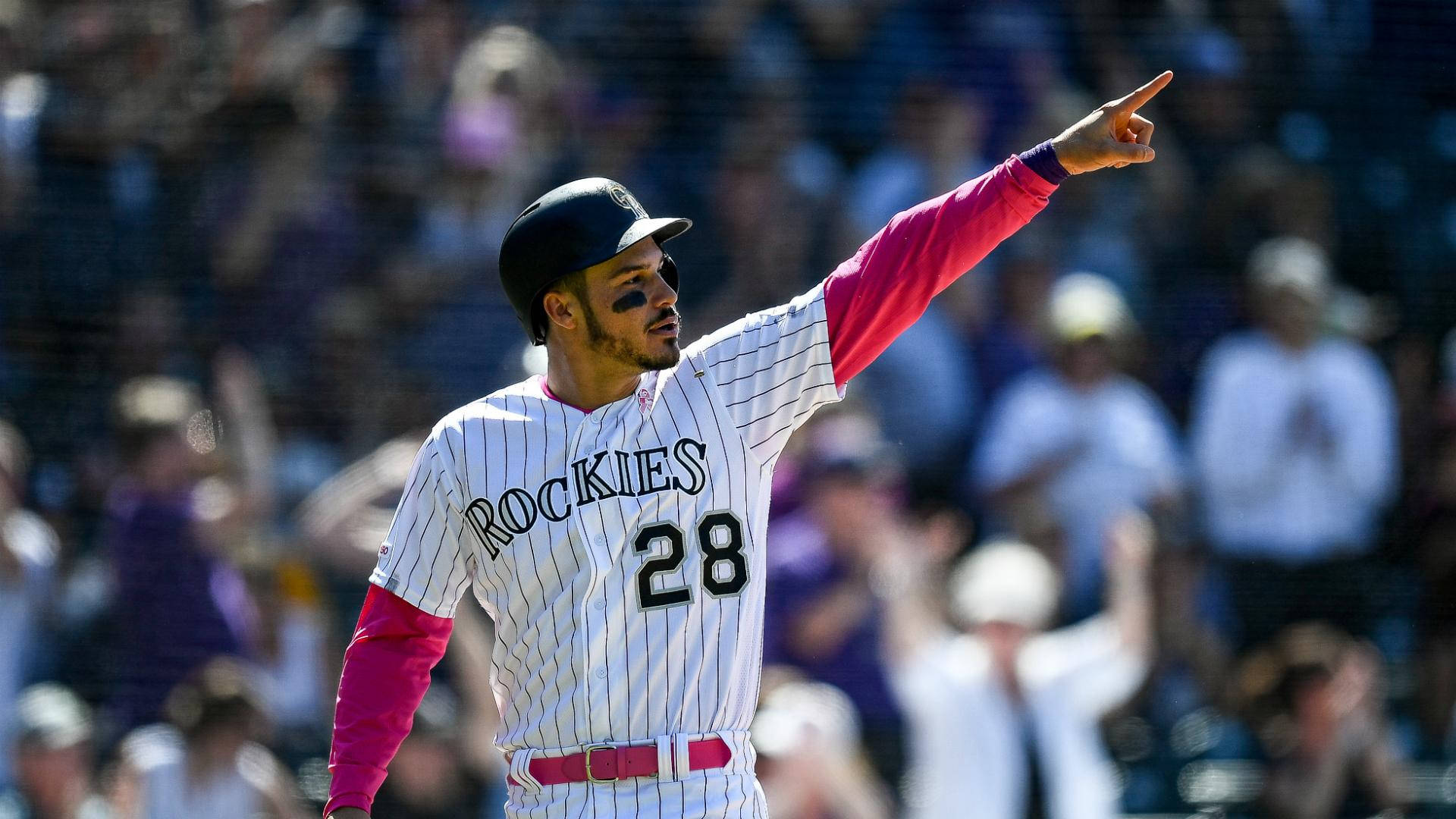 Arenado 桌布 壁紙 — 一名身穿洛磯隊球衣的棒球運動員在明亮的球場燈光下勝利地指向人群。
