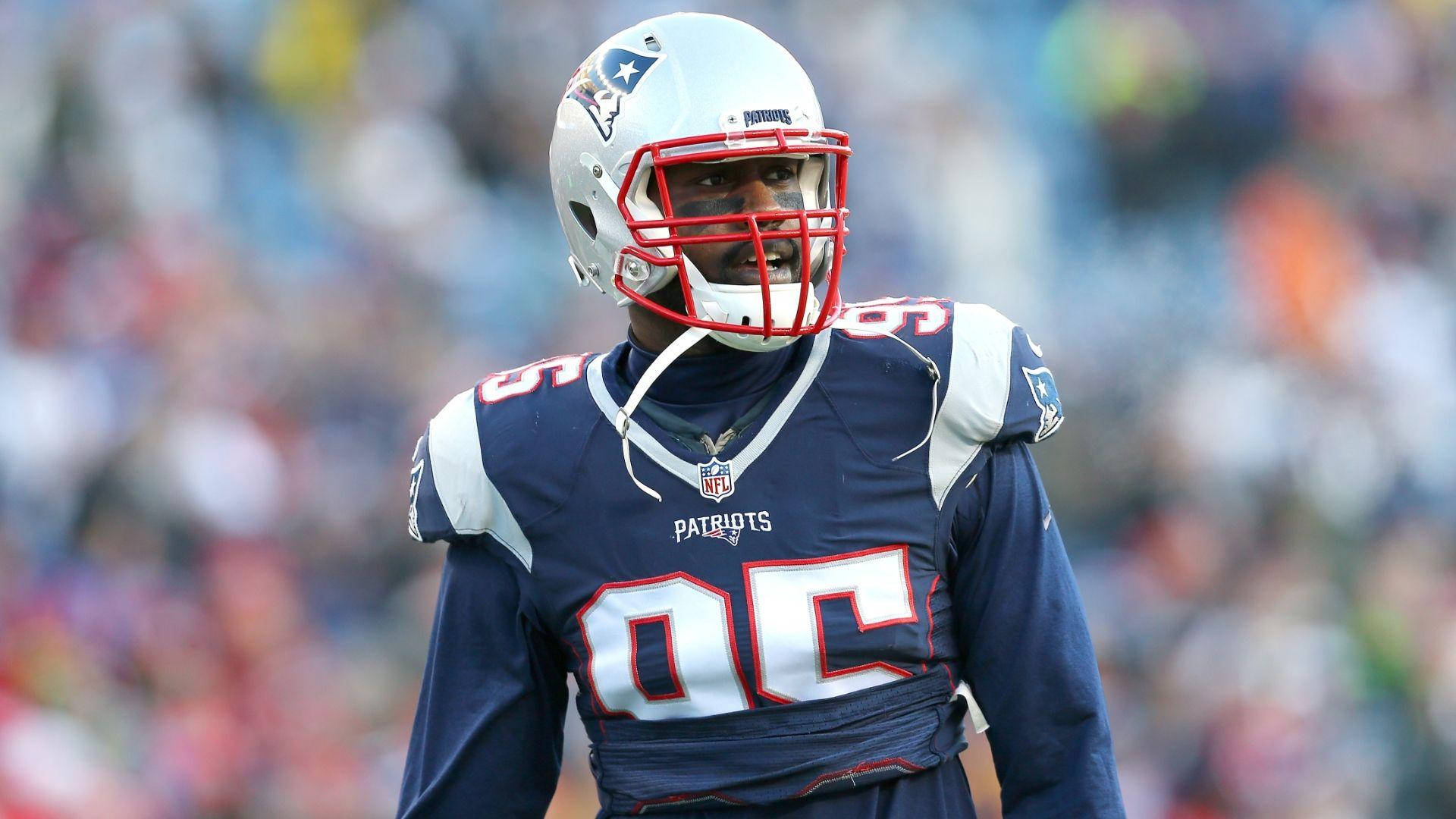New England Patriots 桌布 壁紙 — 一名身穿海軍藍色球衣、帶有紅色和白色點綴的新英格蘭愛國者隊美式足球員在比賽期間站在球場上。
