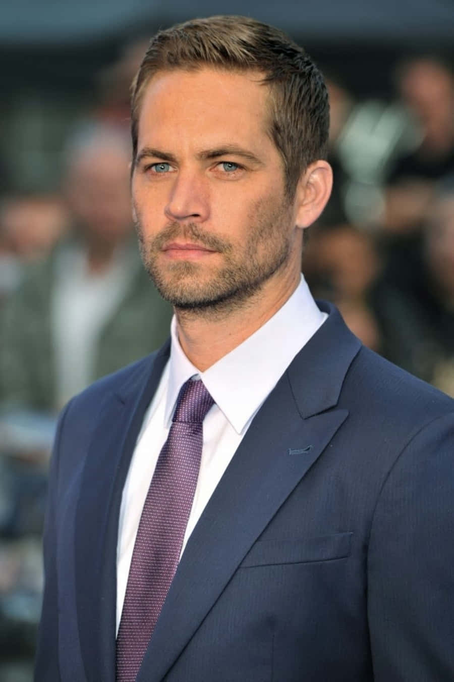 Paul Walker 桌布 壁紙 — 一名身穿海軍藍西裝和圖案領帶的男士，表情嚴肅地直視鏡頭的清晰肖像。