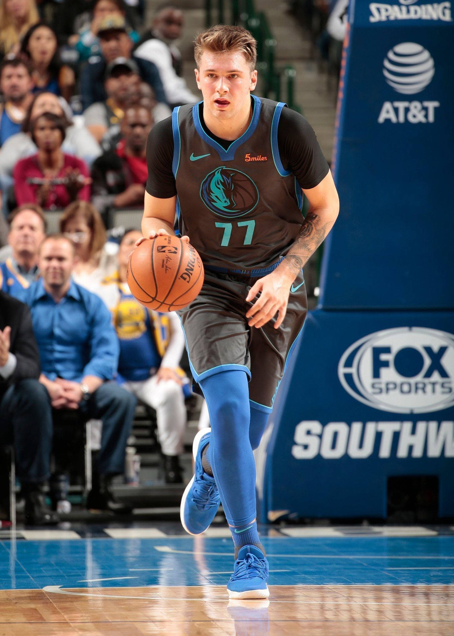 Luka 桌布 壁紙 — 一名身穿深色球衣、號碼77的籃球運動員在比賽中運球，表情專注。