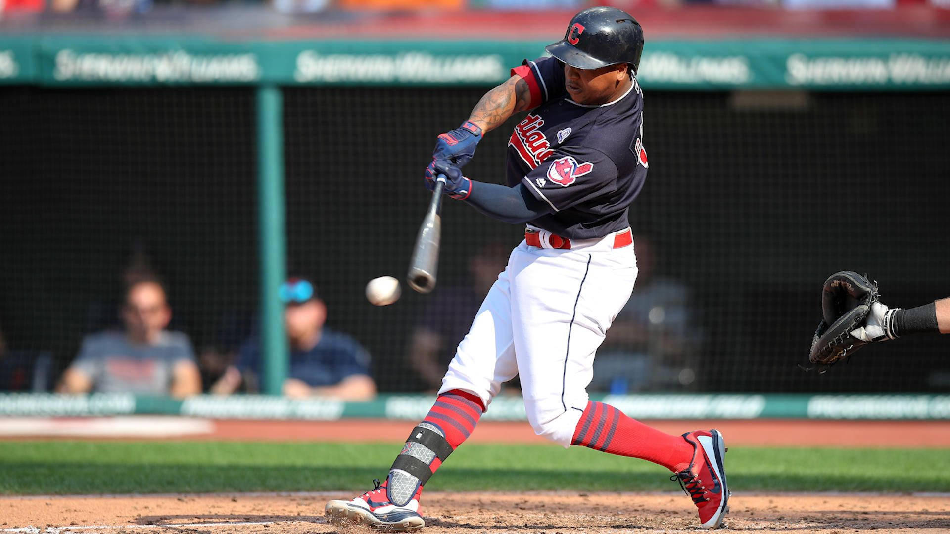 Jose Ramirez 桌布 壁紙 — 一名身穿深色球衣的棒球選手在日間比賽中揮棒擊球，背景有觀眾。