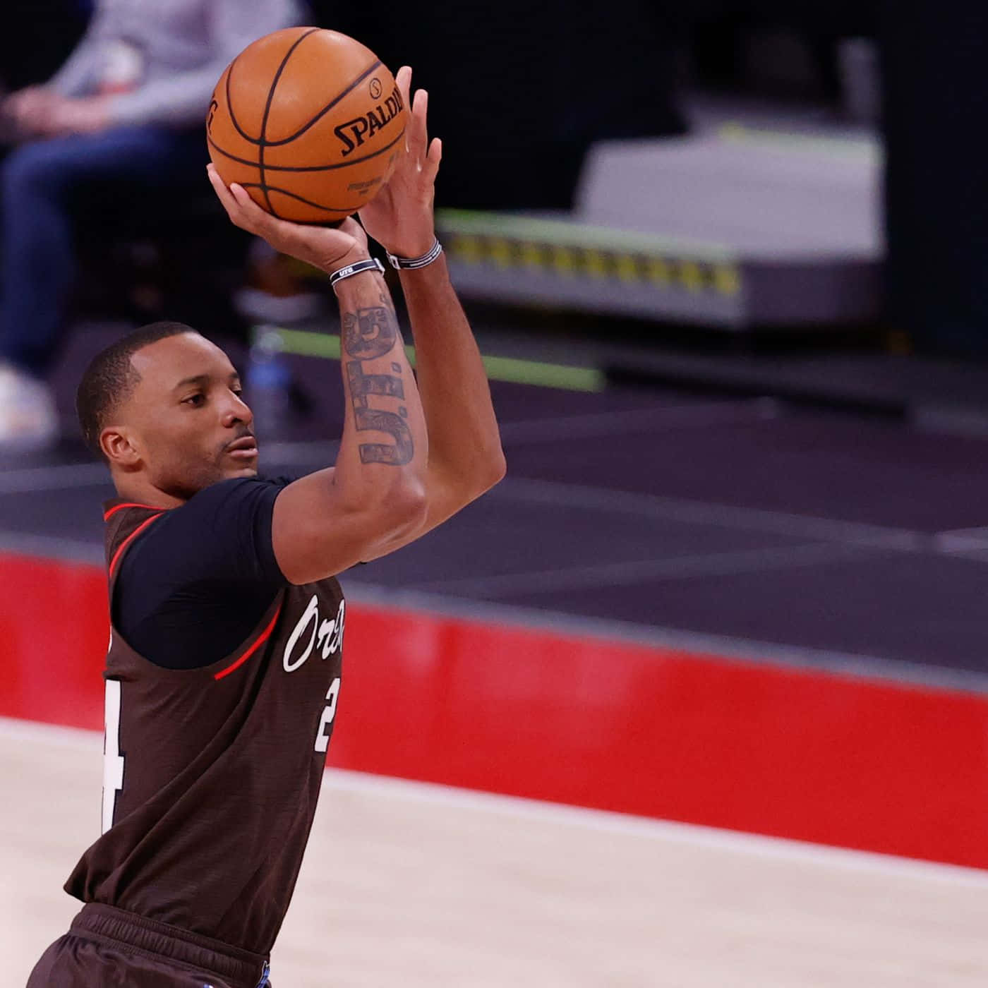 NBA 桌布 壁紙 — 一名身穿深色球衣的籃球運動員在帶有紅色邊線的球場上，全神貫注地準備投擲 Spalding 籃球。