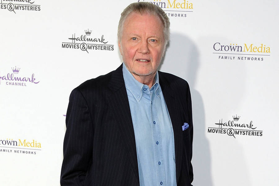 Jon Voight 桌布 壁紙 — 一名身穿深色細條紋西裝和淺藍色襯衫的男子自信地站在Hallmark品牌活動背景前。
