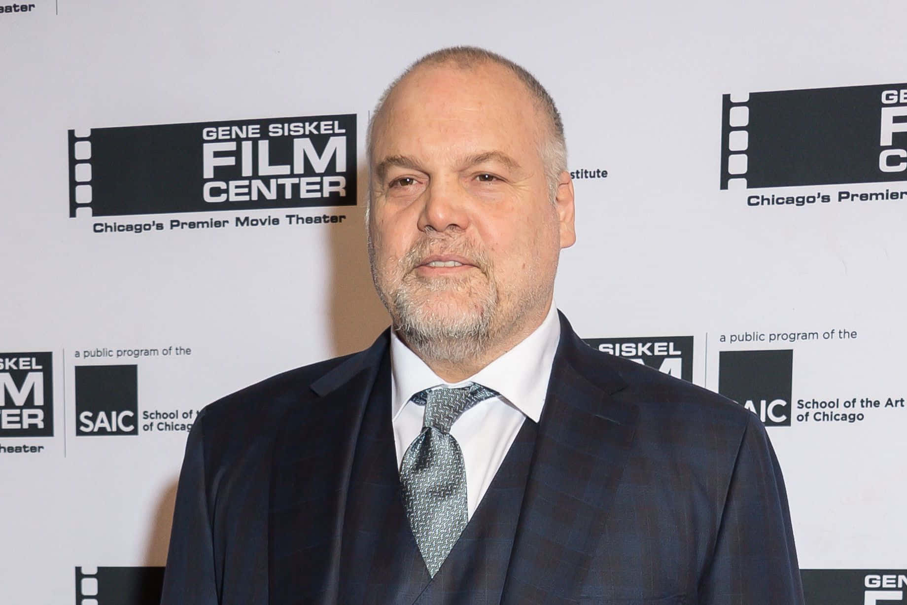 Vincent D'onofrio 桌布 壁紙 — 一名身穿深色西裝和圖案領帶的男子自信地站在電影中心活動中，身後有標誌。