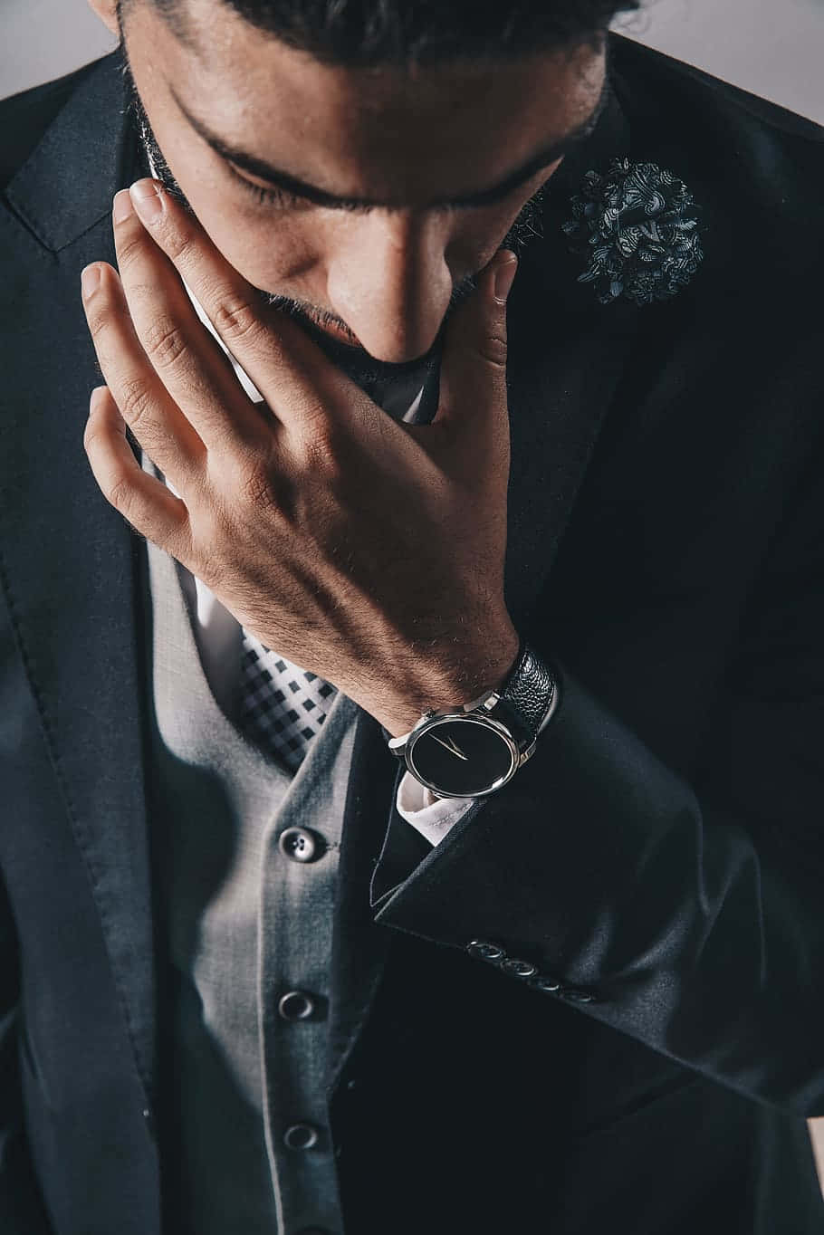 style 桌布 壁紙 — 一名身穿深色西裝的男子，一手將電話貼在耳邊，另一隻手放在臉部附近，正在進行專注的對話。