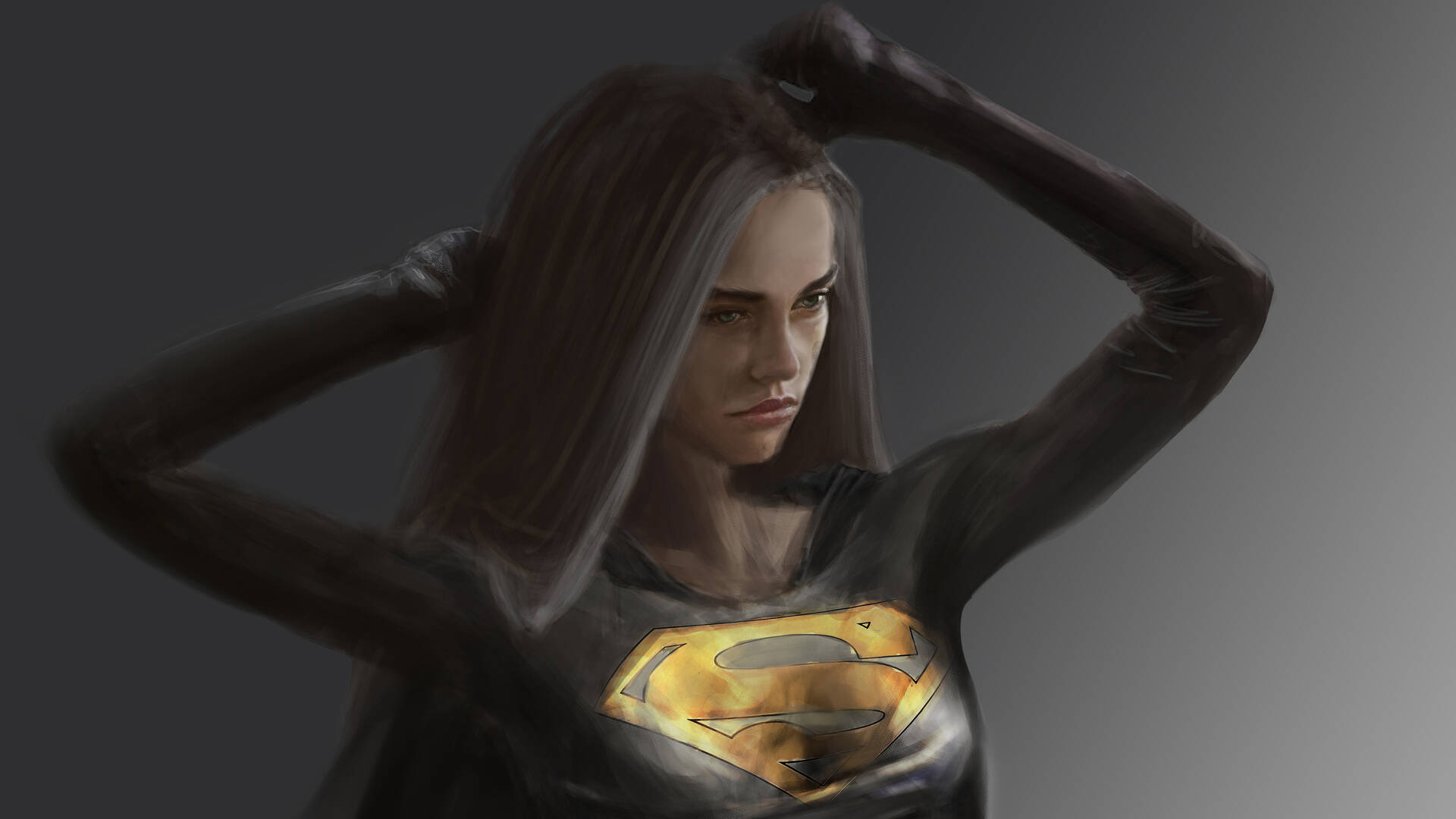 Supergirl 桌布 壁紙 — 一名身穿深色超級女孩服裝、帶有發光S盾牌的女性在灰色背景前將手臂舉過頭頂。