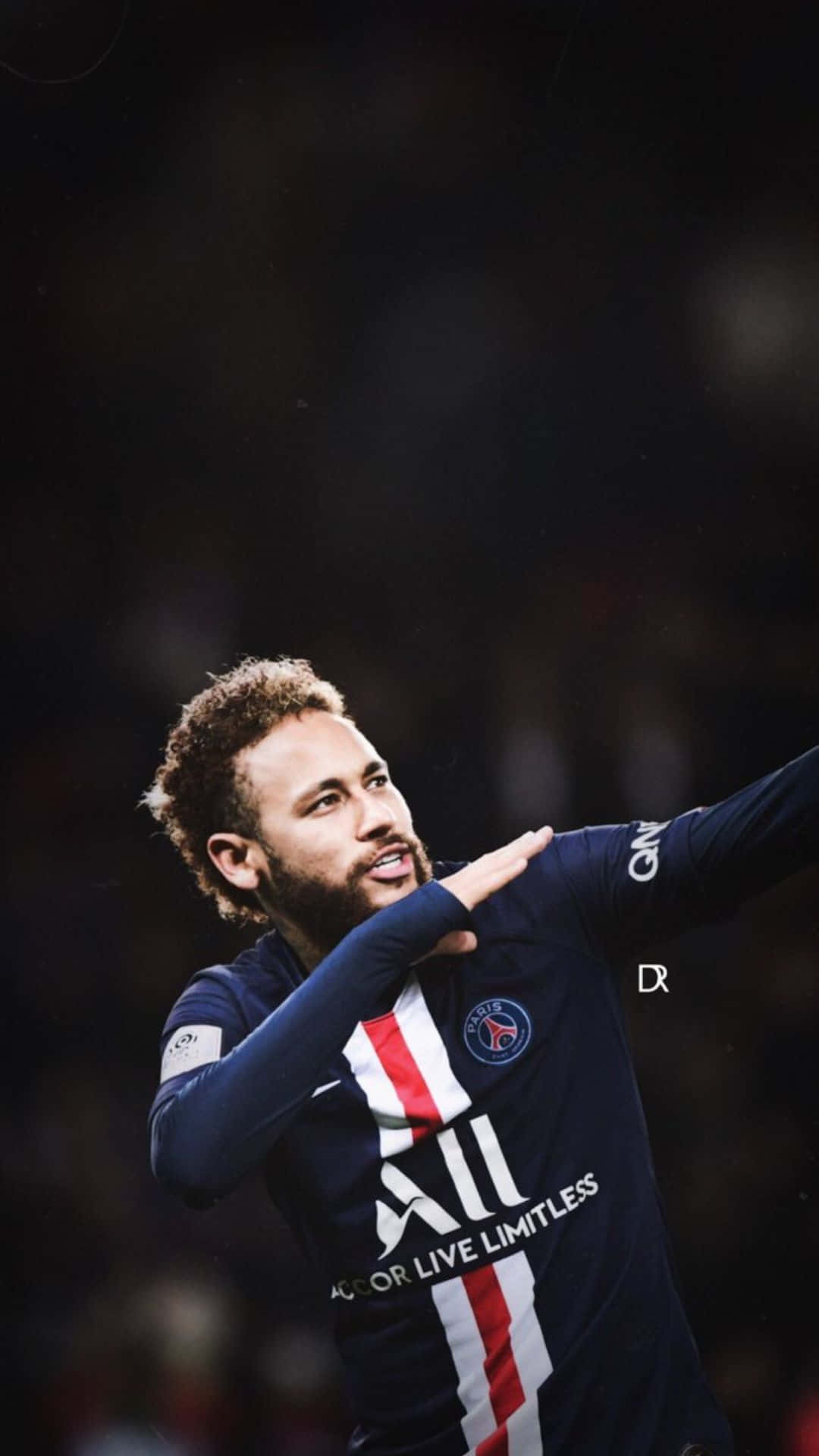 Neymar iPhone 桌布 壁紙 — 一名身穿深藍色PSG球衣的足球運動員在模糊的體育場人群中張開雙臂慶祝。